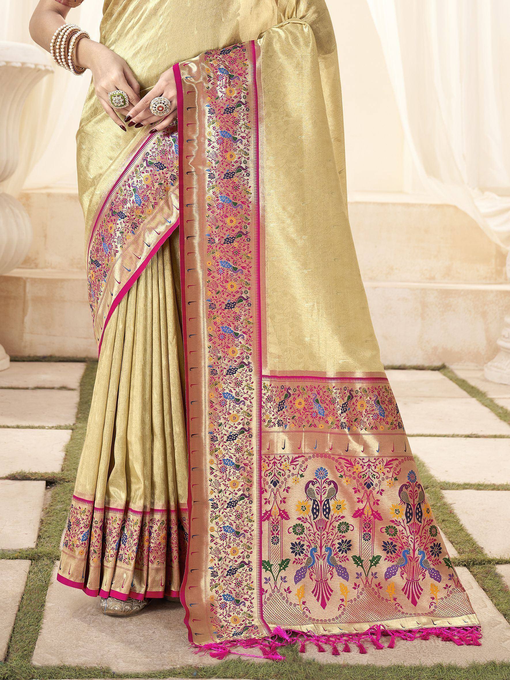 Gold saree with vibrant pink border and peacock floral embroidery, perfect for Indian ethnic wear occasions.