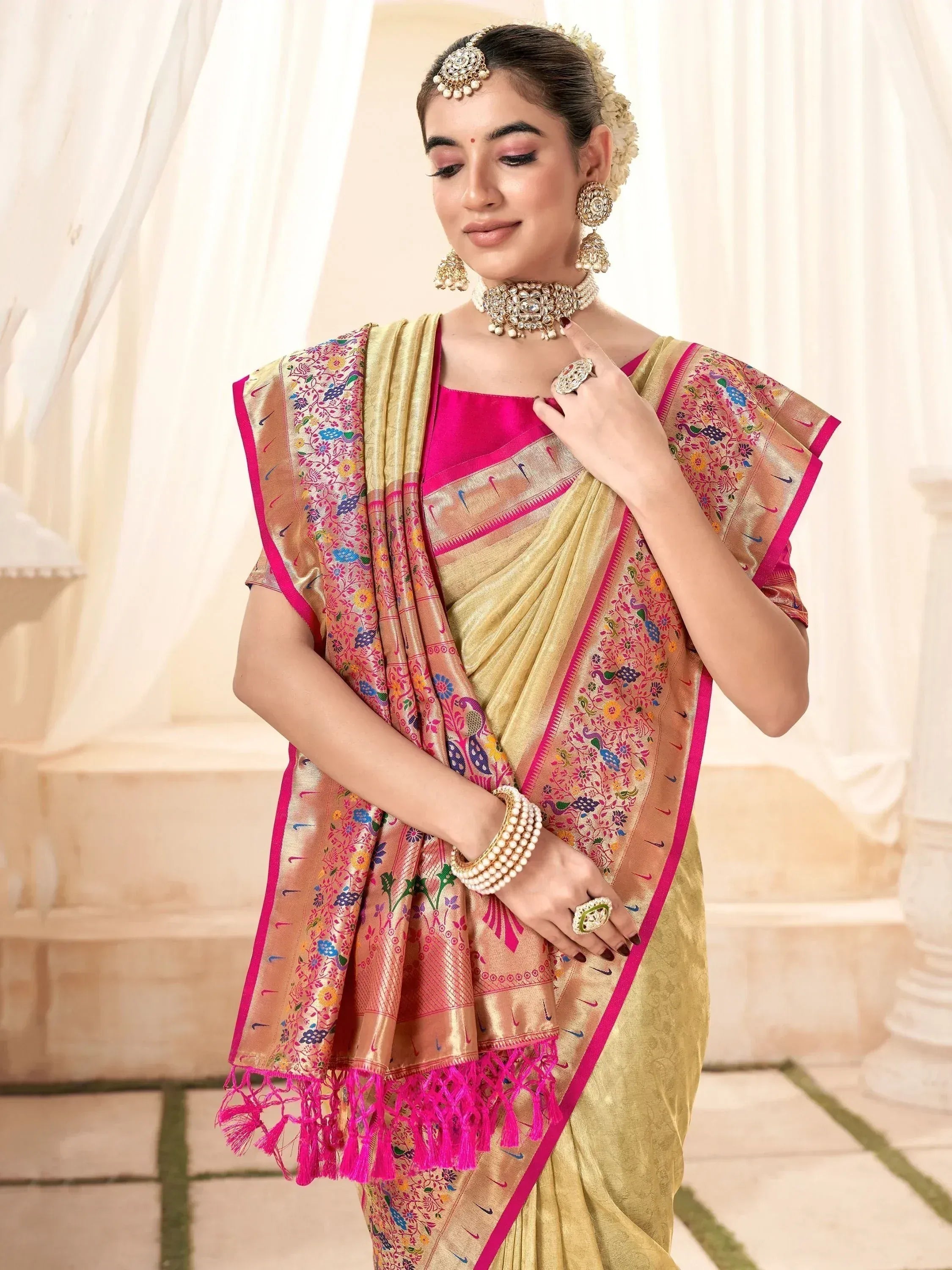 Woman in golden saree with pink border and floral embroidery, traditional Indian ethnic wear
