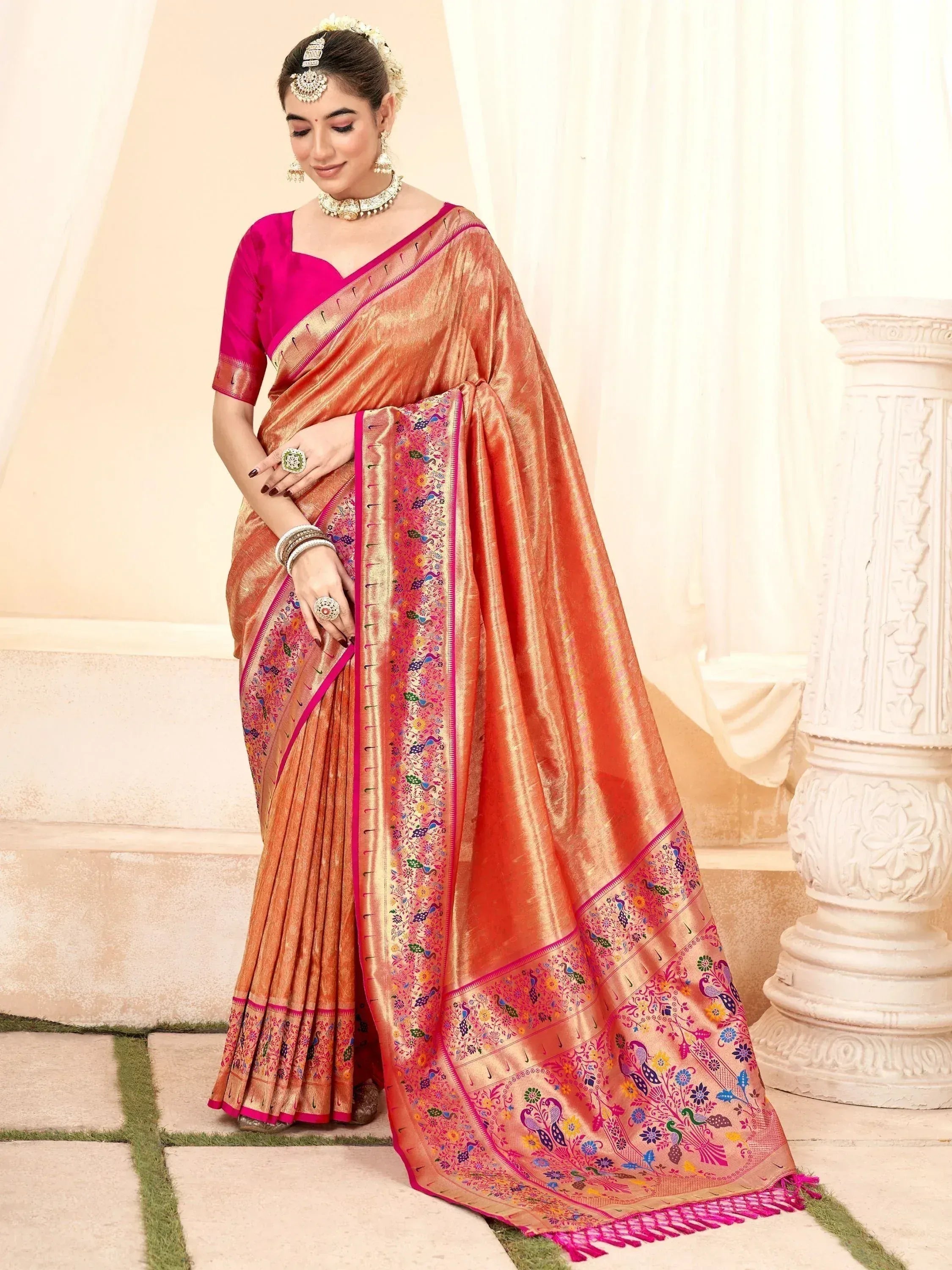 Elegant peach silk saree with peacock embroidery and pink border, paired with matching blouse for Indian ethnic wear
