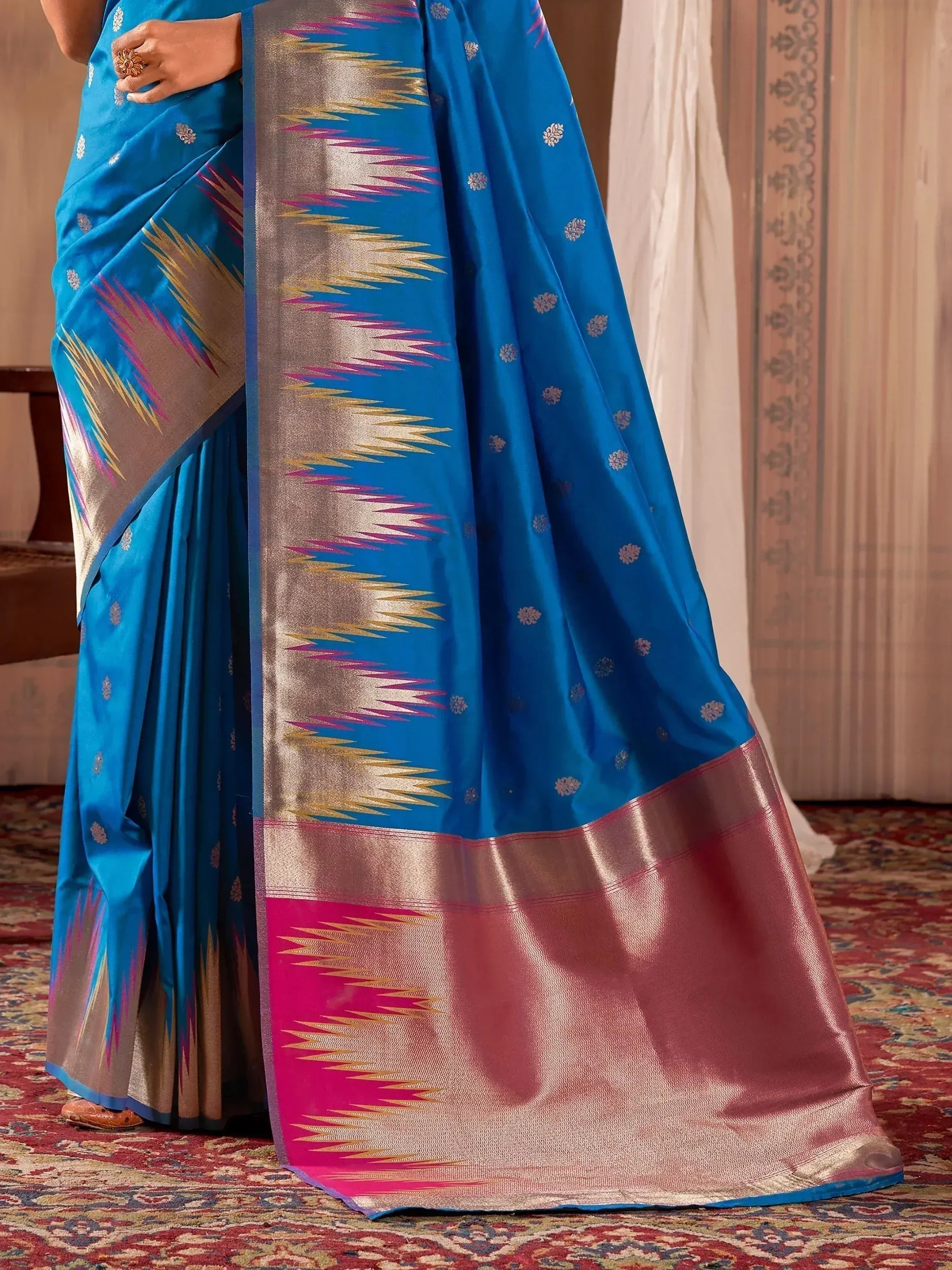 Vibrant blue silk saree with gold and pink ikat border, perfect for Indian ethnic wear occasions