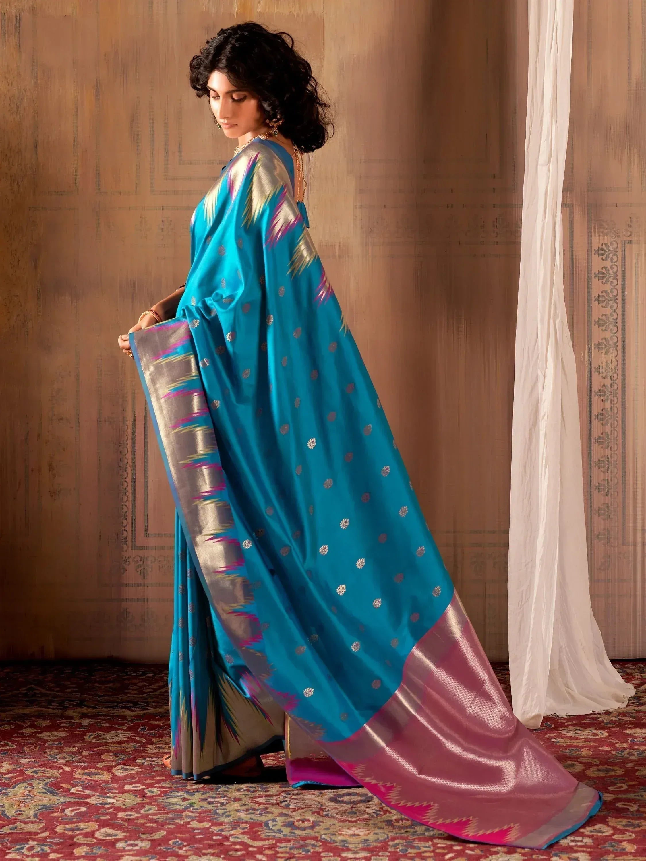 Elegant turquoise saree with silver and pink ikat border, perfect for Indian ethnic wear occasions.
