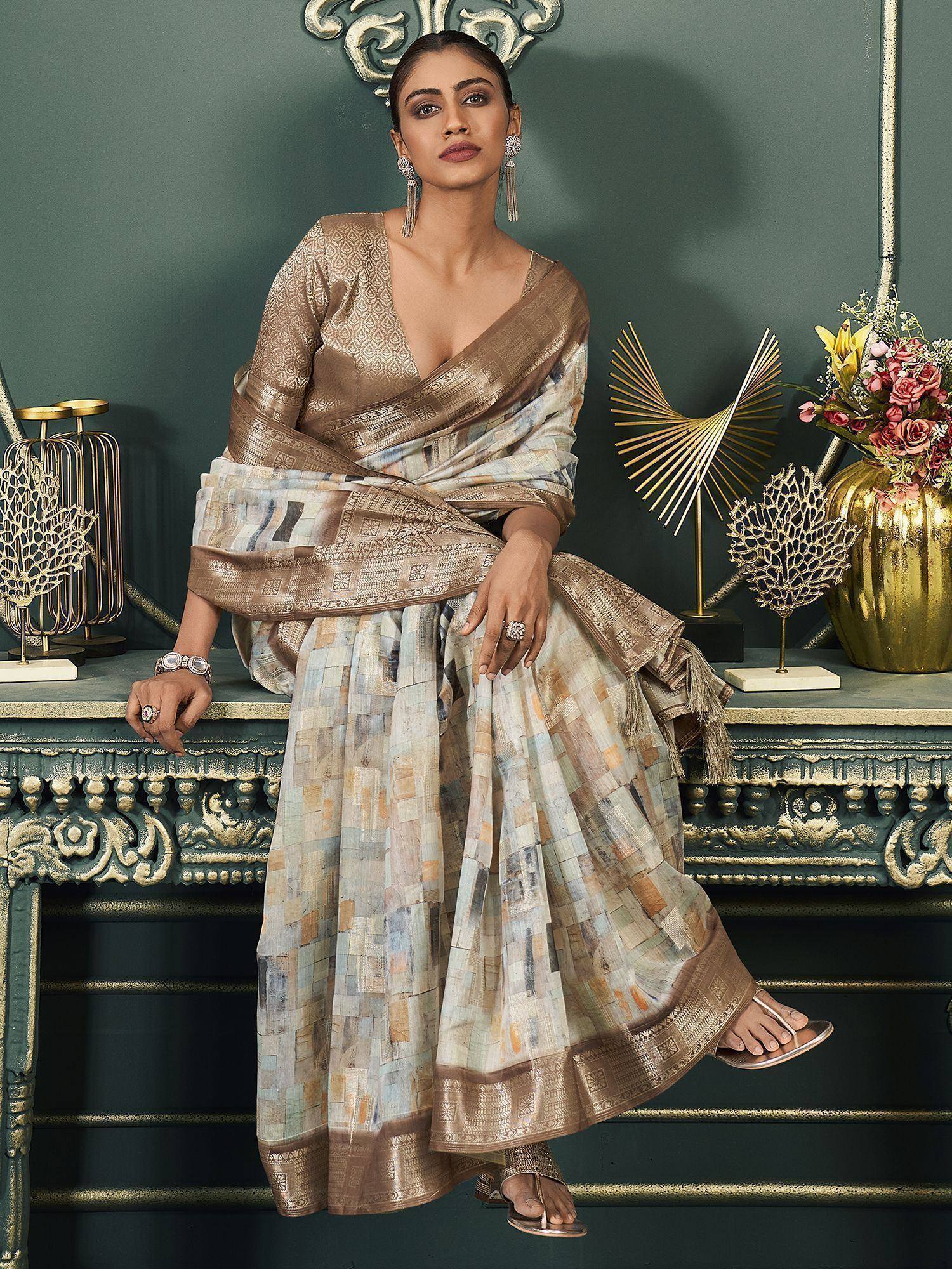 Woman in elegant ethnic saree with geometric print and gold border, styled for festive occasions
