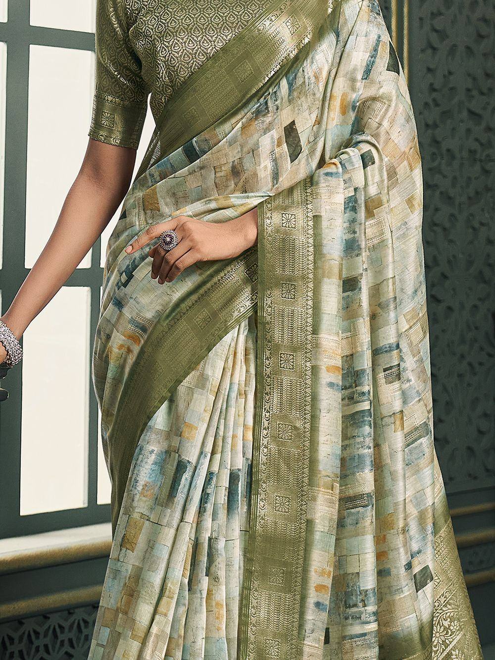 Olive green designer saree with abstract patchwork print and woven border, paired with matching blouse.
