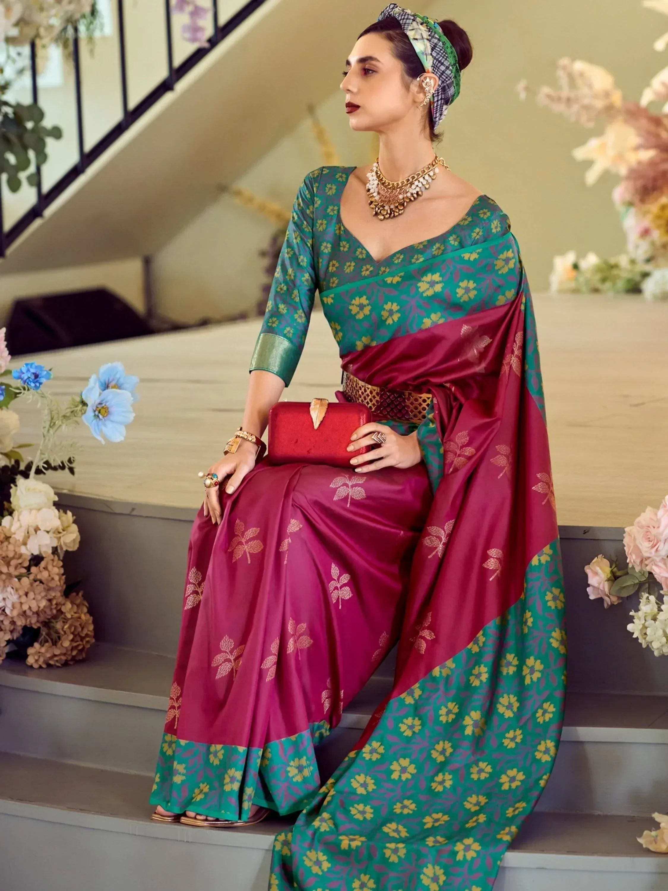 Woman in elegant green and maroon floral saree with gold jewelry, styled for ethnic occasions