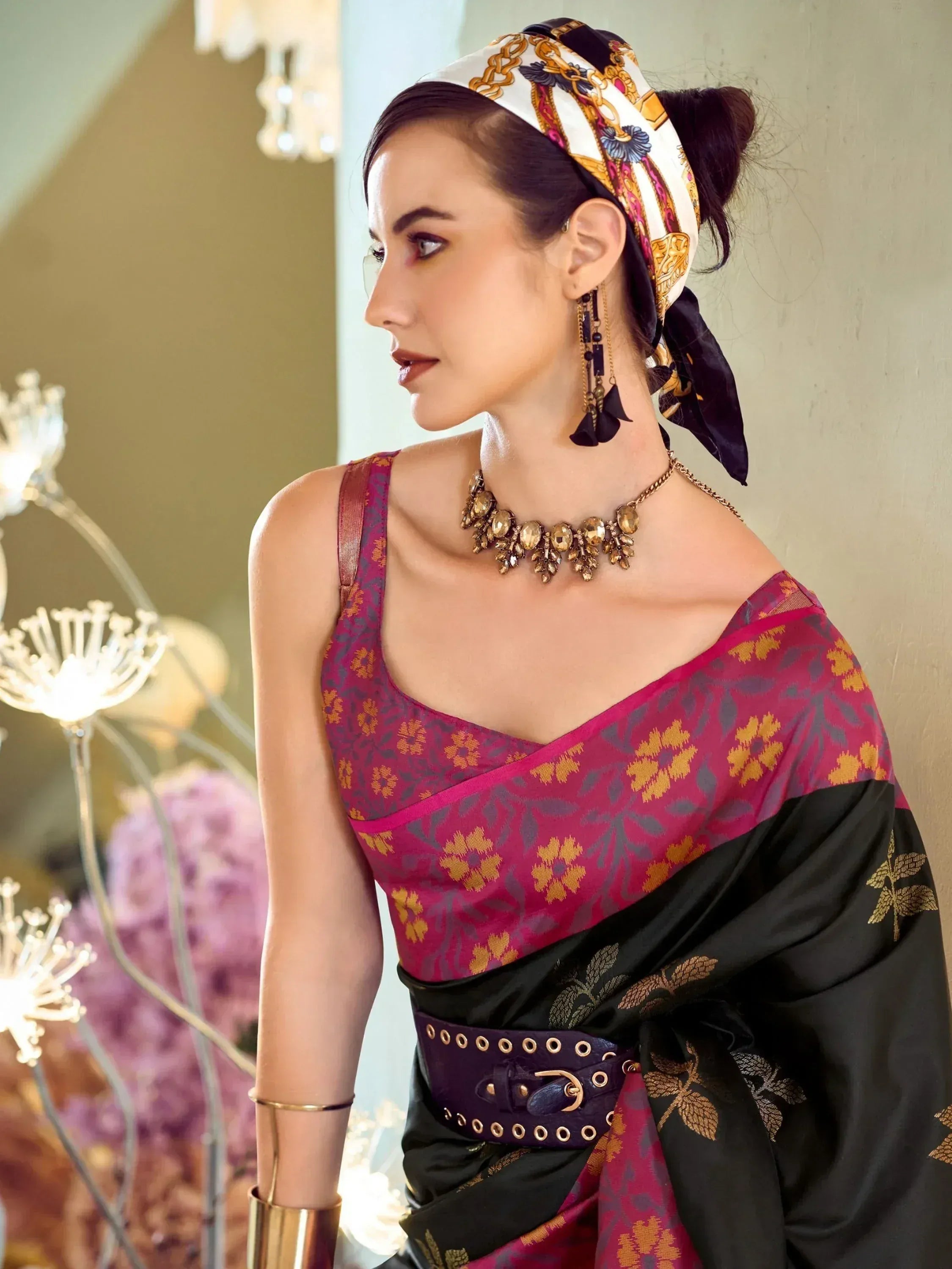 Woman in ethnic saree with floral print, statement jewelry, and patterned headscarf, styled for festive occasions