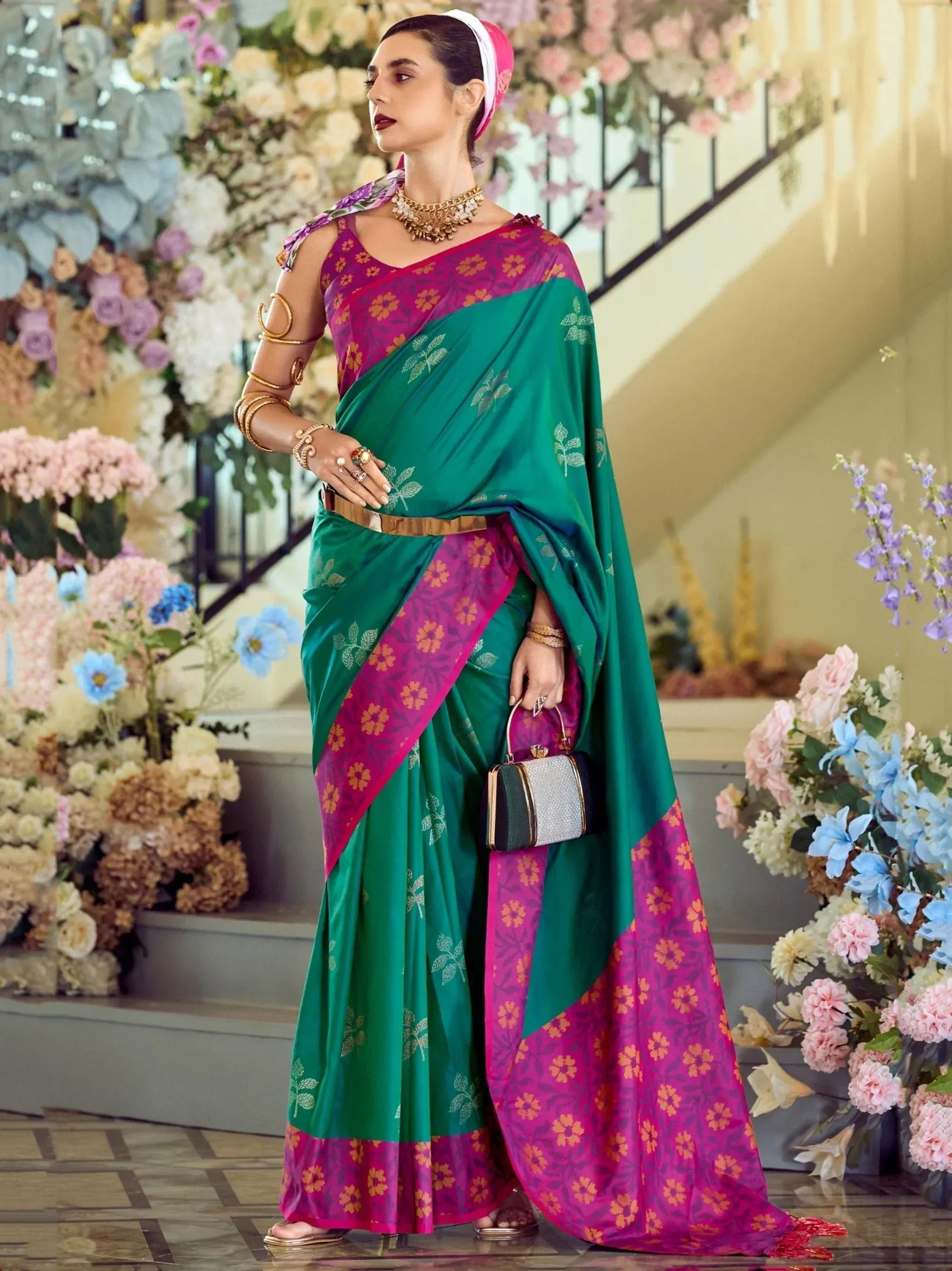 Woman in green and magenta floral saree with gold jewelry, perfect for Indian ethnic occasions