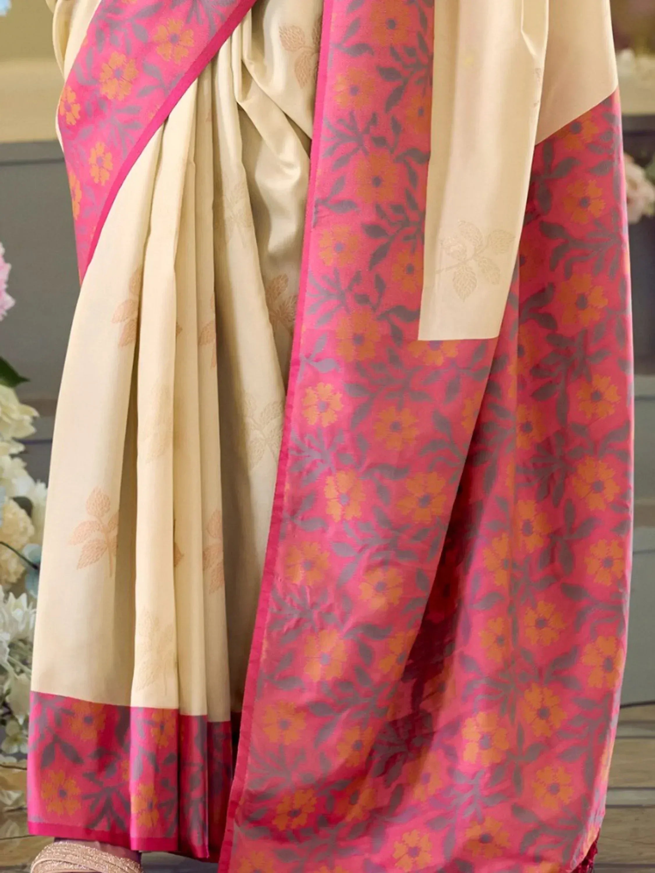 Cream saree with pink floral border, perfect for Indian ethnic wear and festive occasions.
