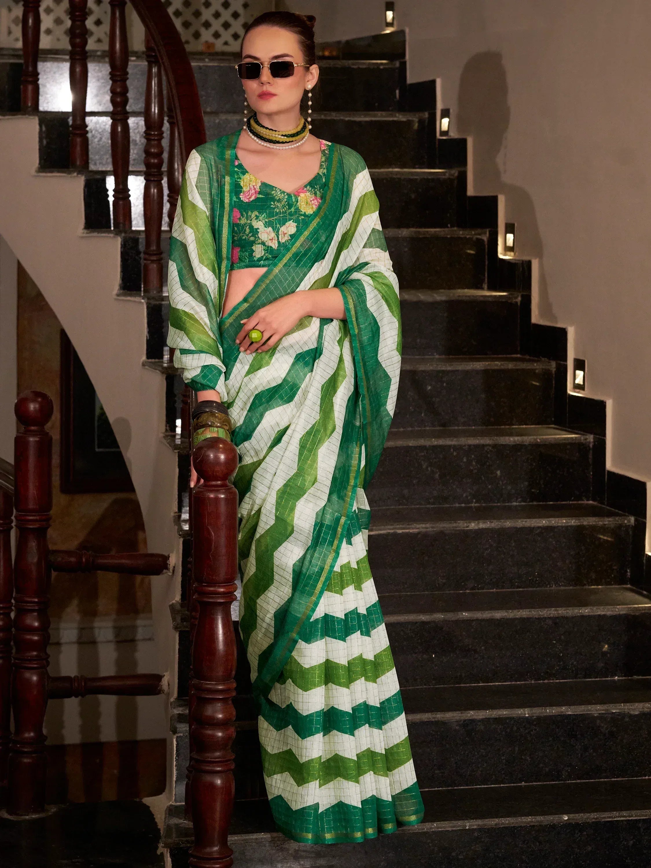 Green and white zigzag pattern saree with floral blouse, styled with sunglasses and pearls