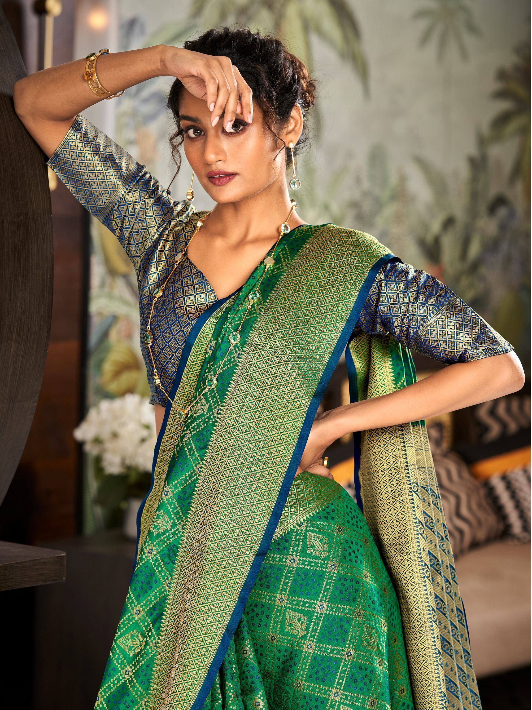 Green and blue patterned designer saree with gold detailing, styled with matching blouse and jewelry