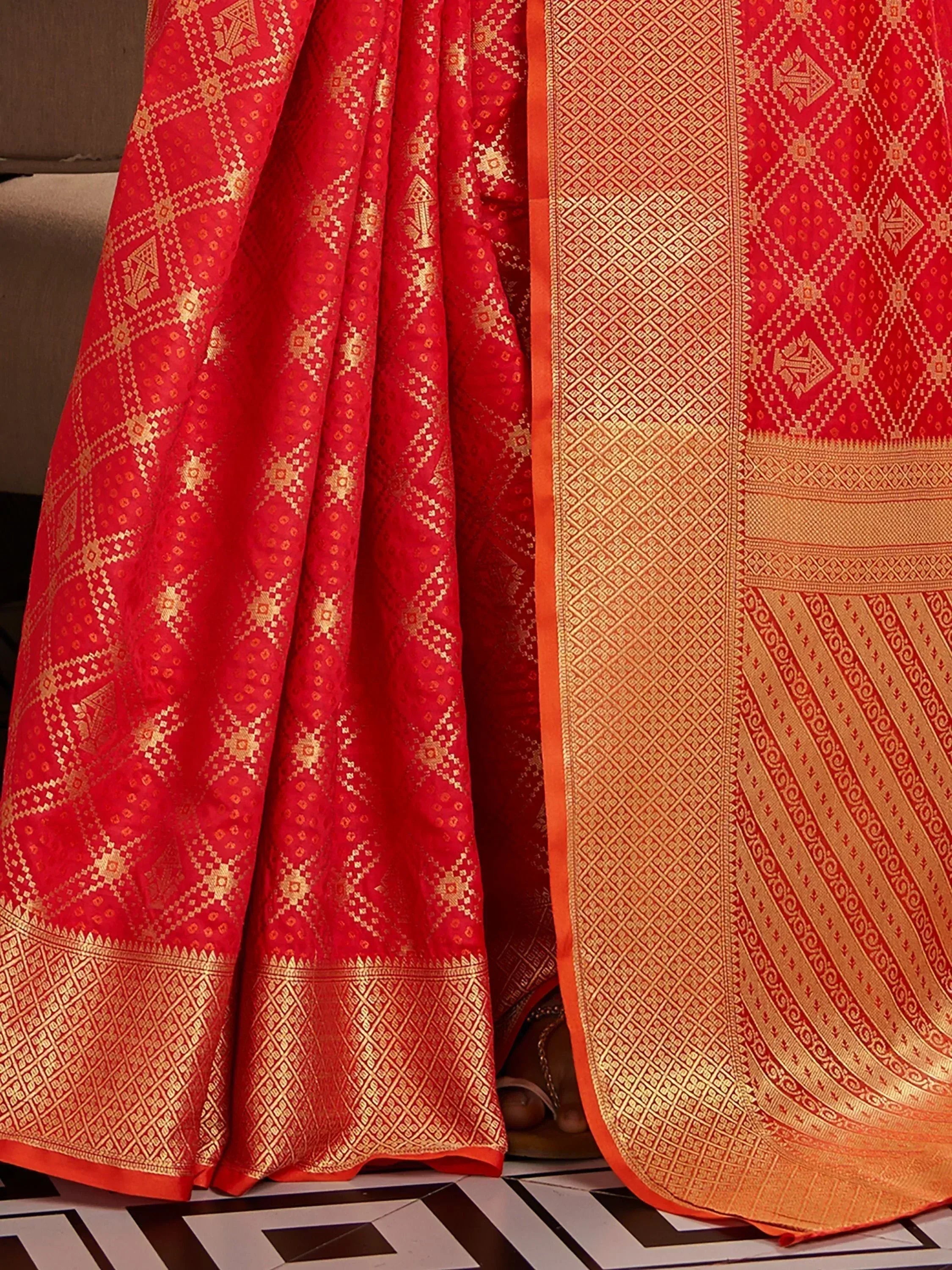 Red and gold designer lehenga choli with intricate geometric patterns, perfect for ethnic wear occasions.