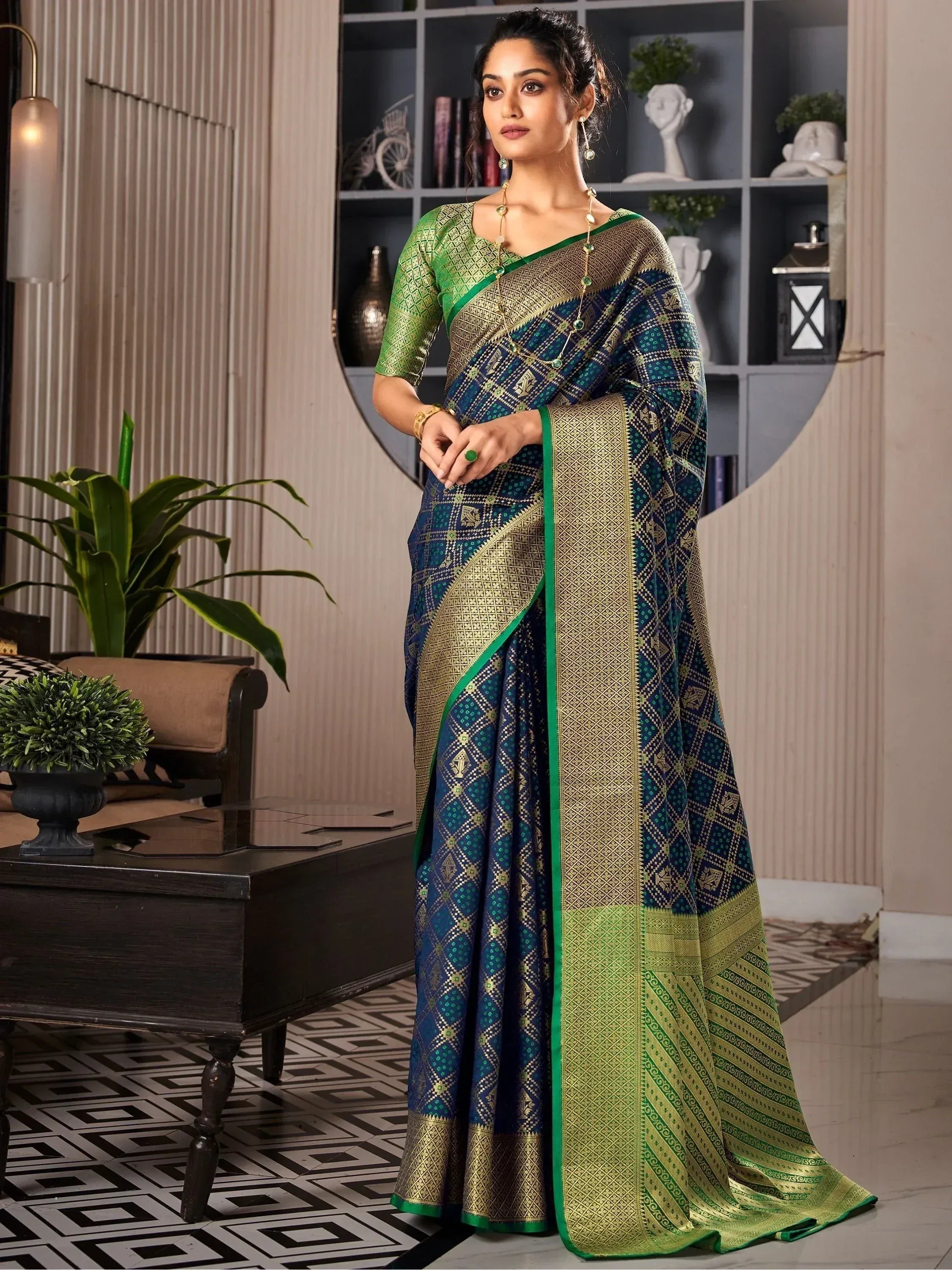 Woman in elegant blue and green designer saree with gold geometric patterns, perfect for ethnic occasions.