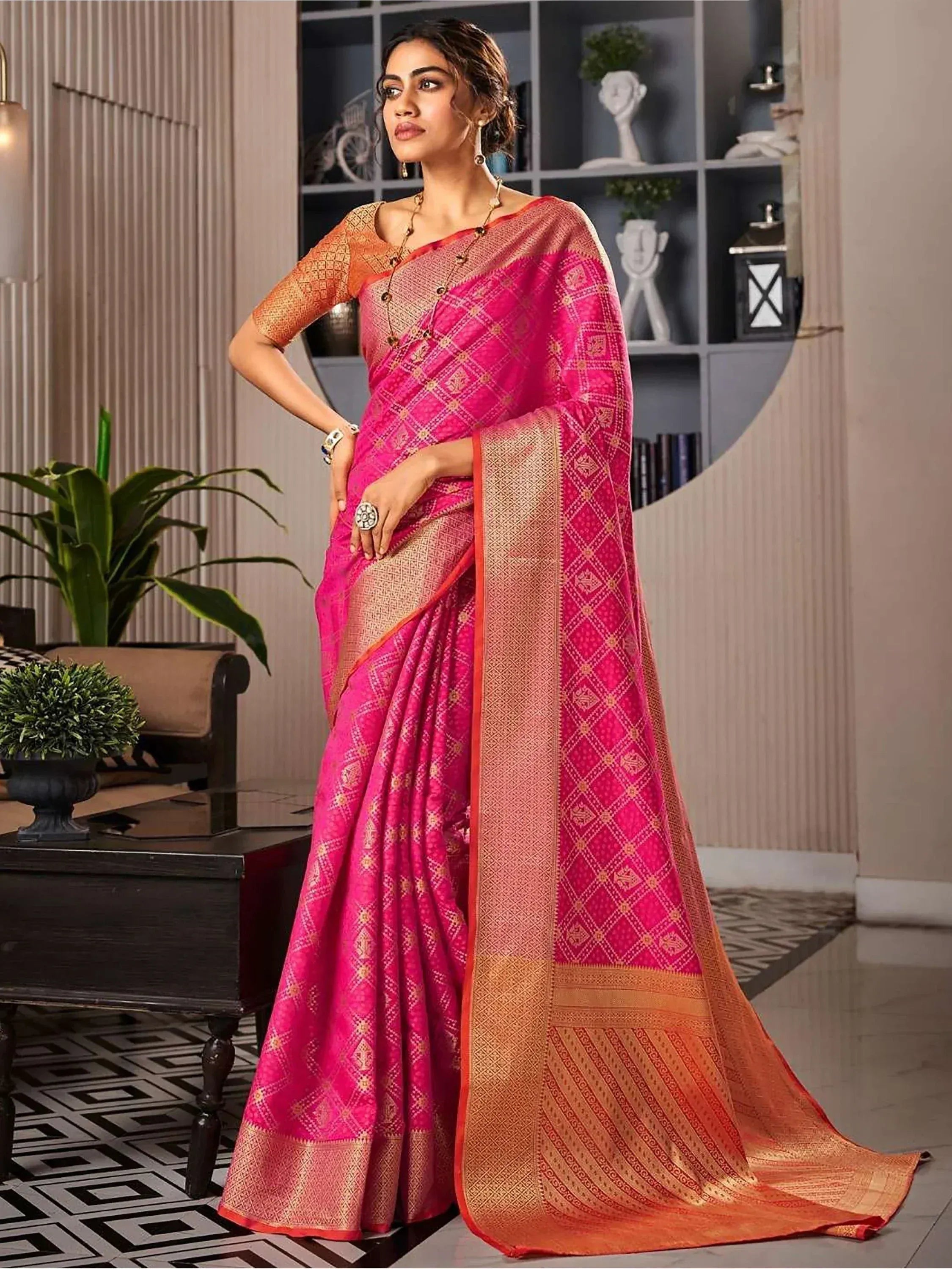 Pink and orange designer saree with gold geometric patterns, perfect for ethnic occasions