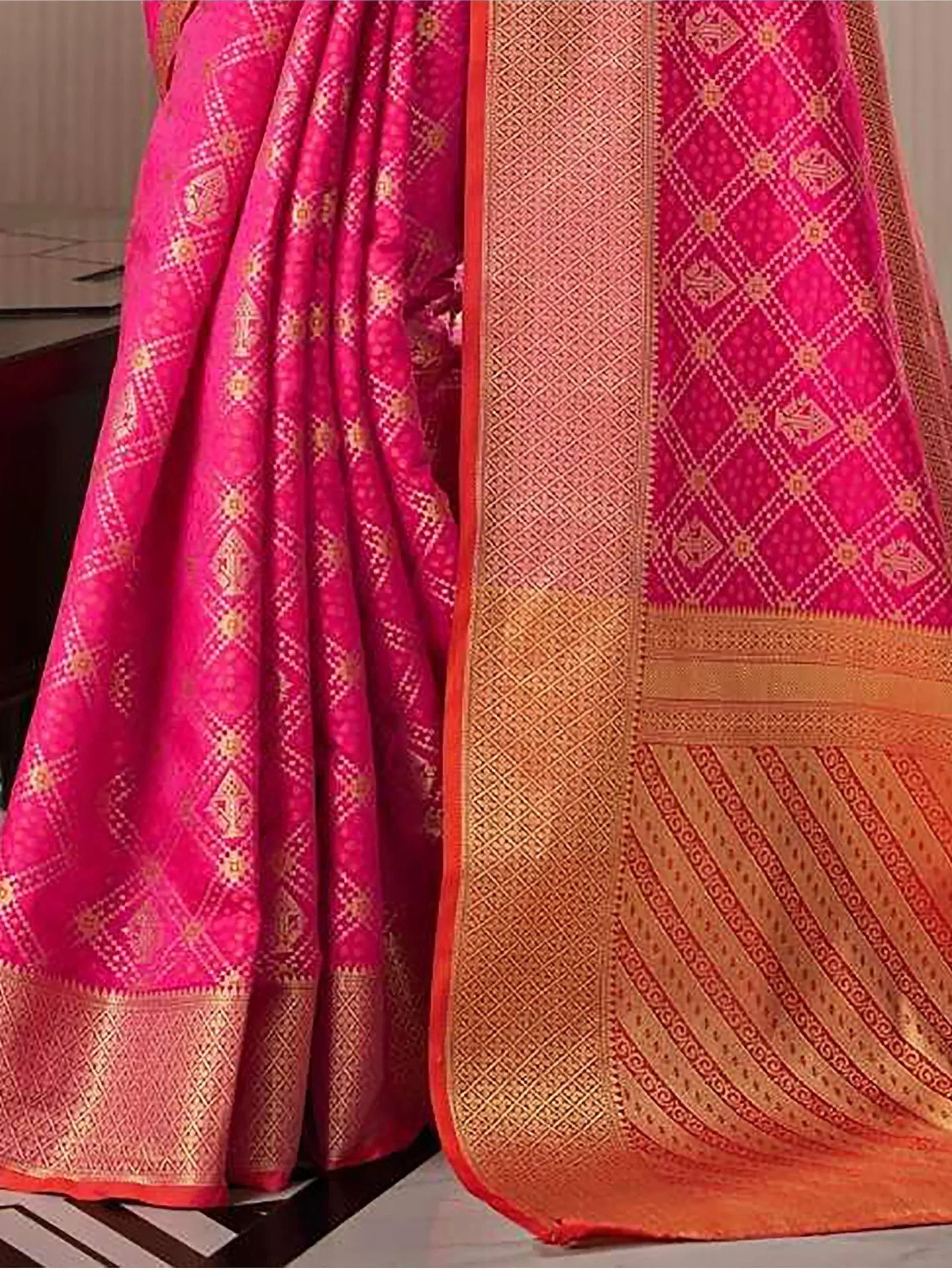 Pink and gold designer saree with intricate geometric patterns and woven border, ideal for ethnic wear