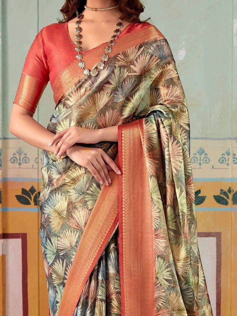 Woman in printed saree with floral pattern and orange border, paired with matching blouse for ethnic wear