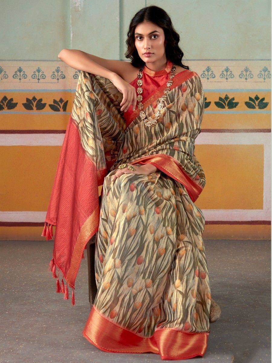 Woman in printed saree with red border and matching blouse, styled with gold jewelry for ethnic wear