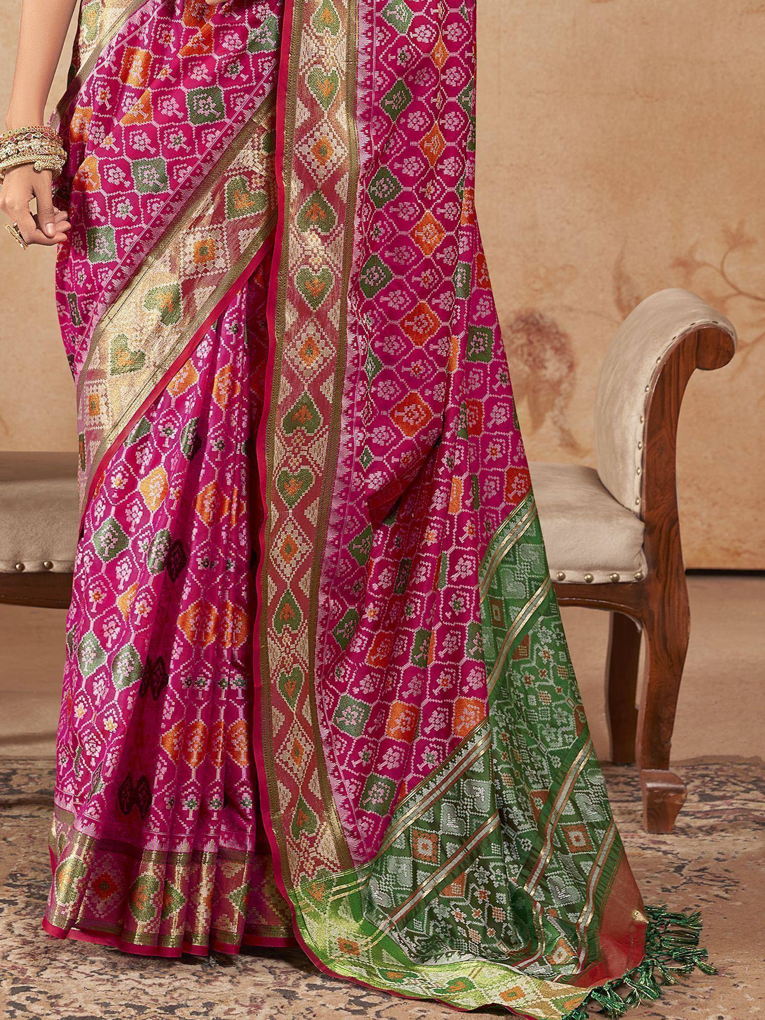 Vibrant pink and green ethnic saree with intricate geometric patterns and gold border, perfect for Indian festive occasions.