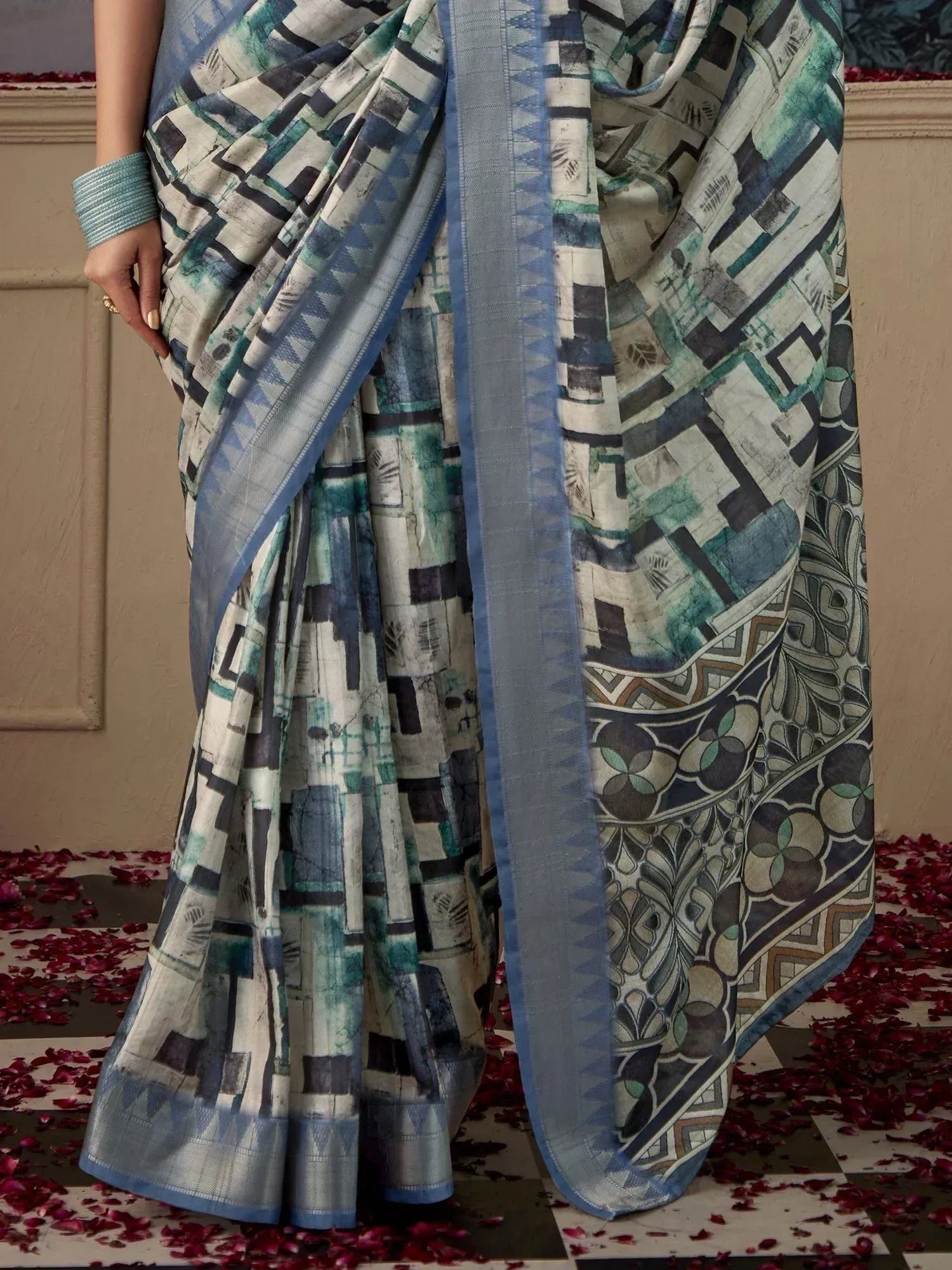 Blue and green printed saree with geometric pattern and woven border, styled with matching bangle