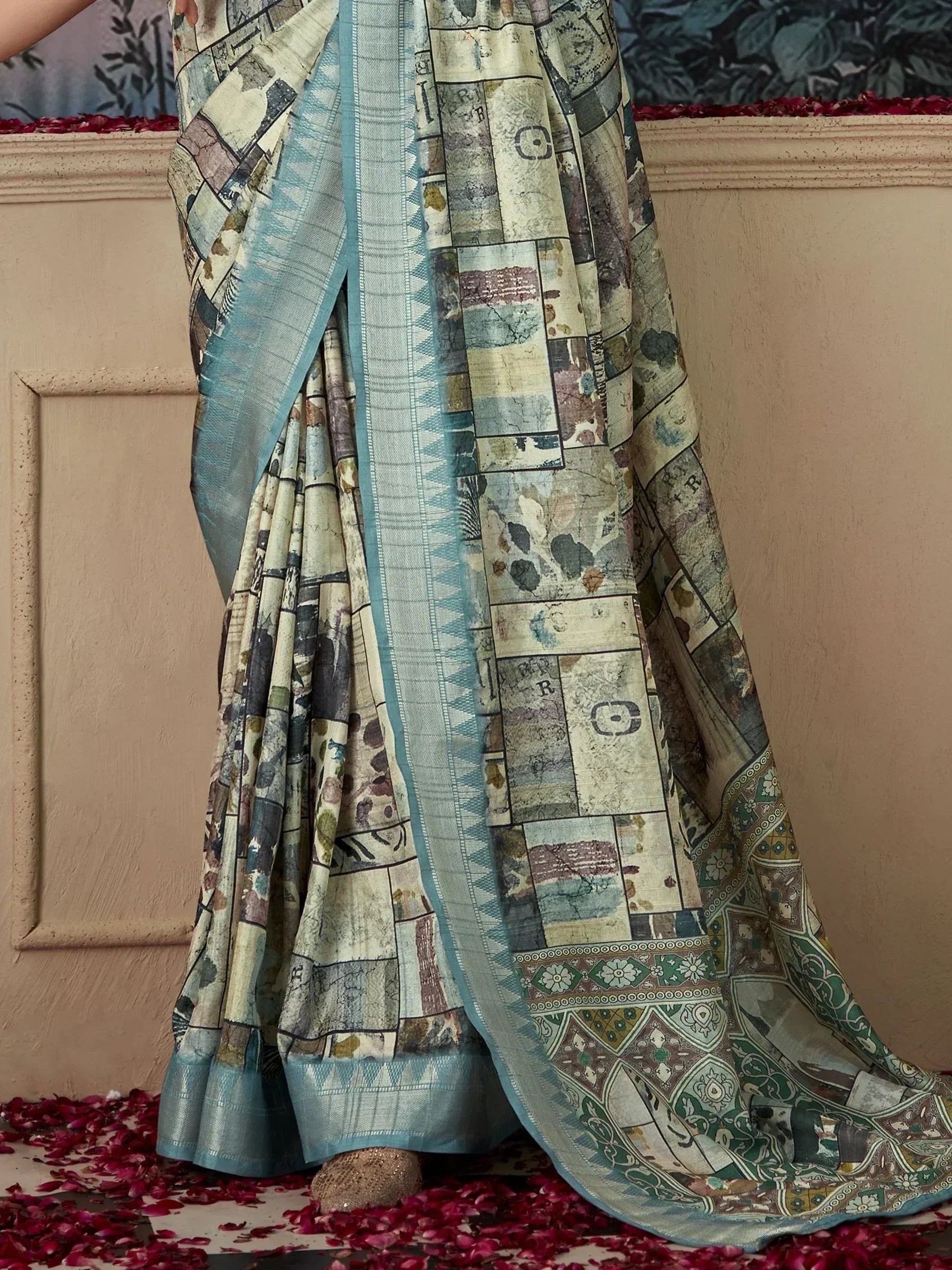 Printed saree with patchwork design and blue border, styled with rose petals for ethnic wear