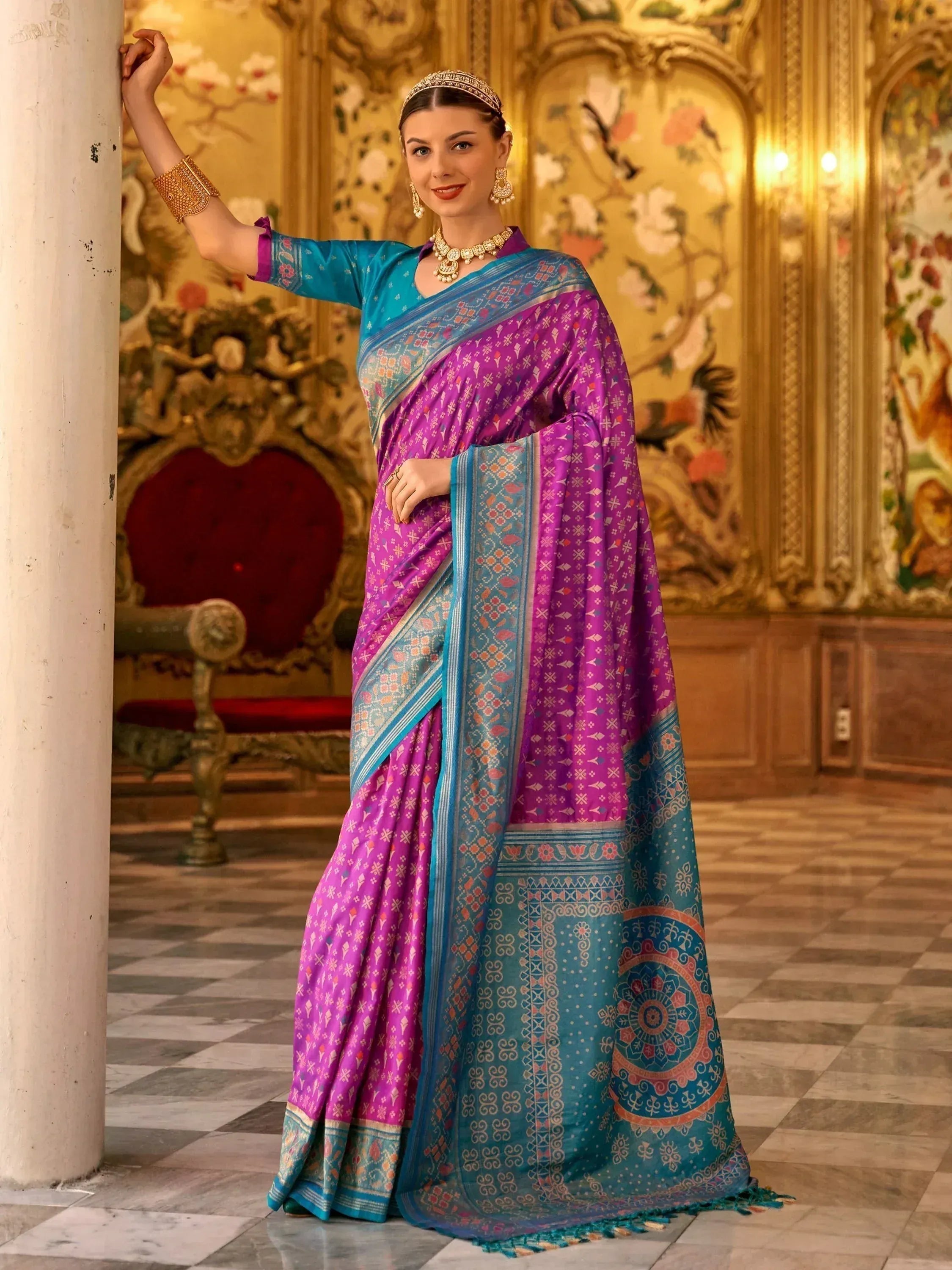 Woman in vibrant purple and teal designer saree with intricate patterns, traditional Indian ethnic wear
