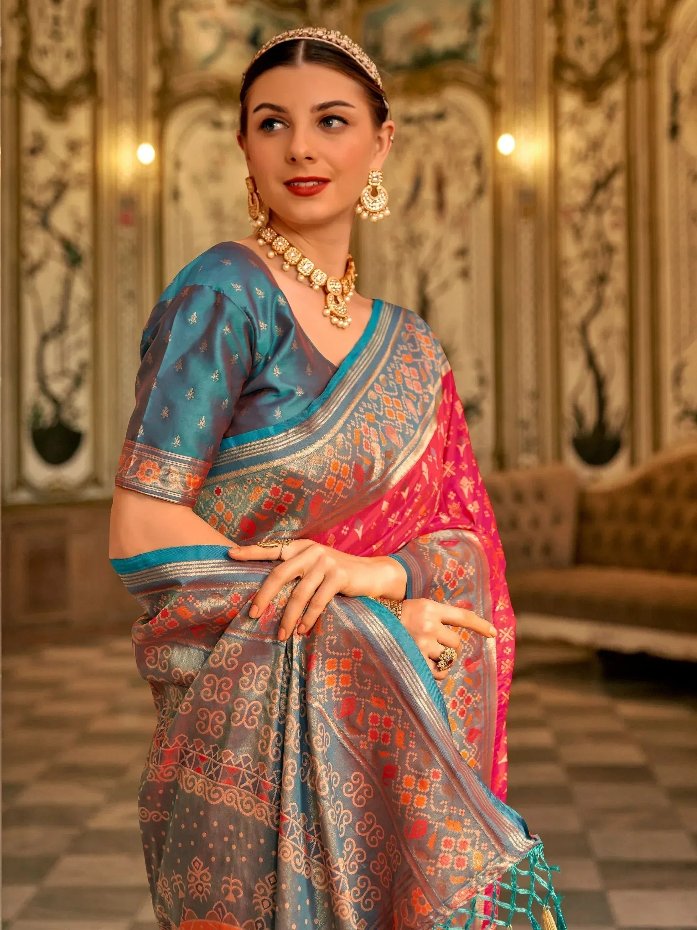 Woman in elegant blue and pink printed saree with gold jewelry, traditional Indian ethnic wear