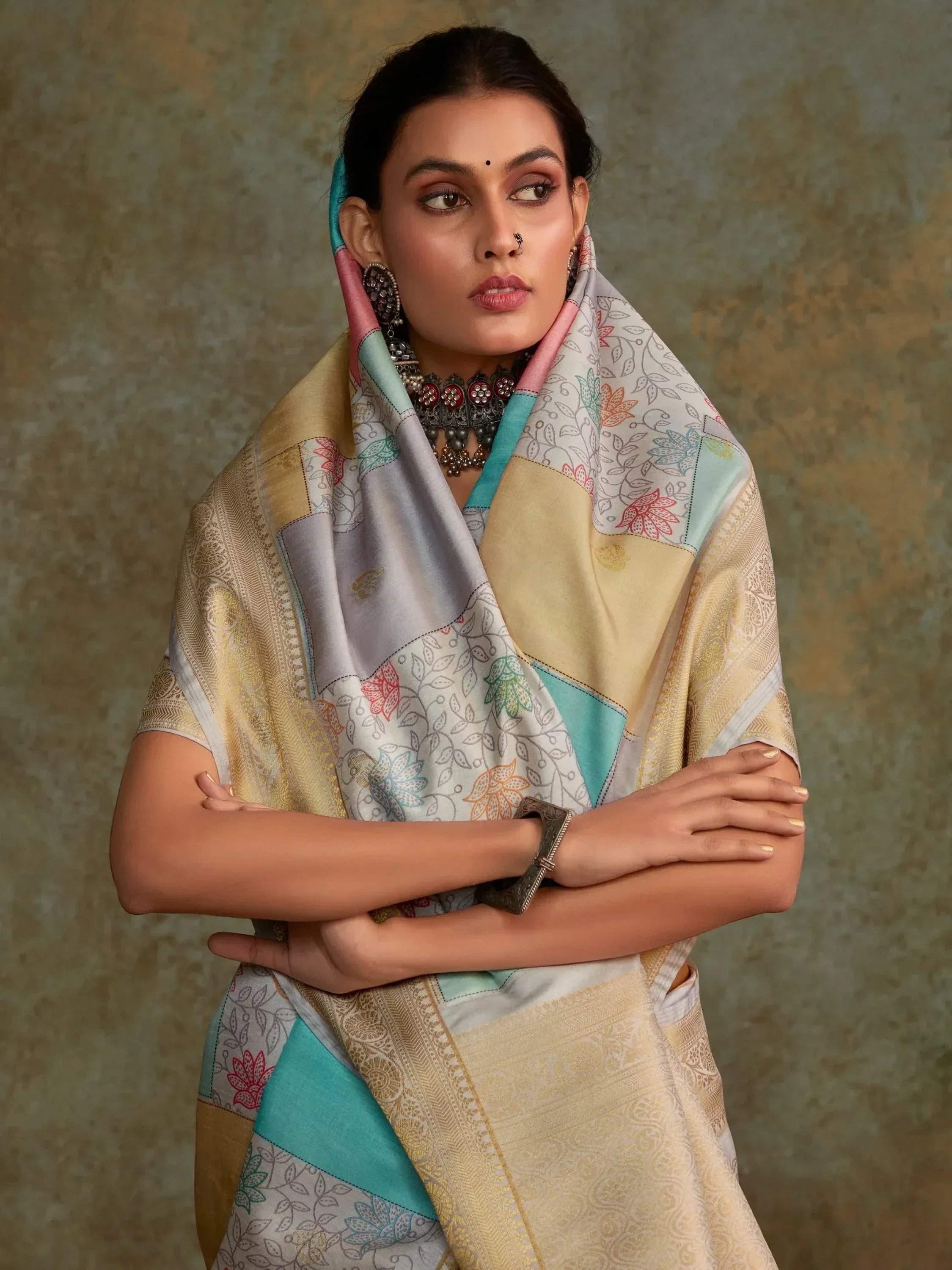 Woman in elegant Indian ethnic saree with floral print and gold border, styled with traditional jewelry