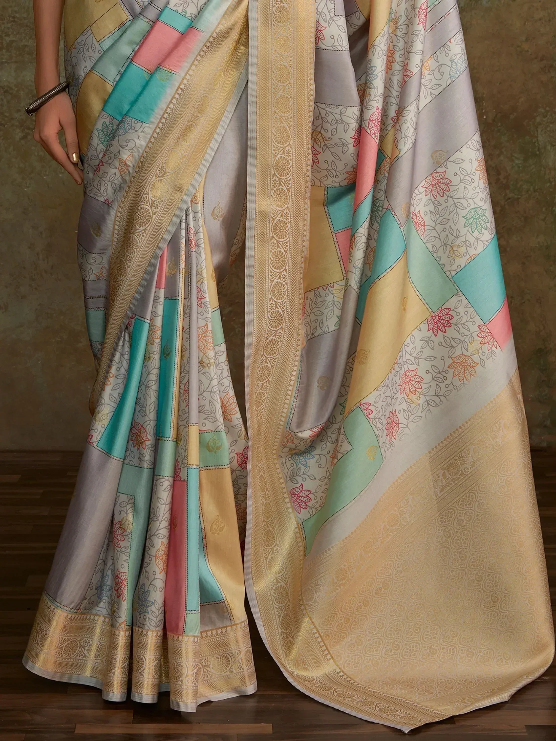 Colorful patchwork saree with floral prints and golden border, ideal for ethnic wear occasions