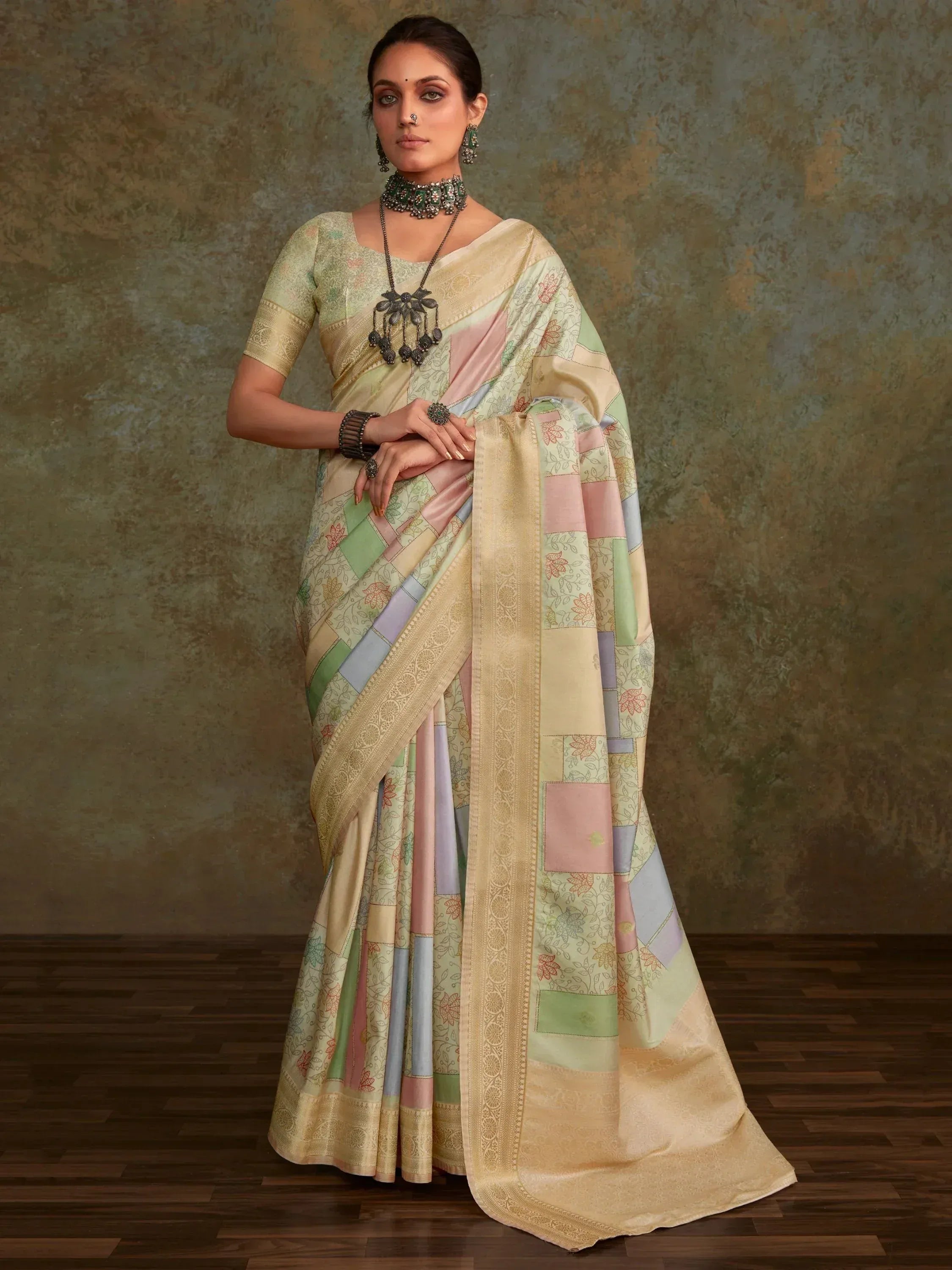 Pastel patchwork saree with floral prints and gold border, styled with ethnic jewelry for Indian occasions