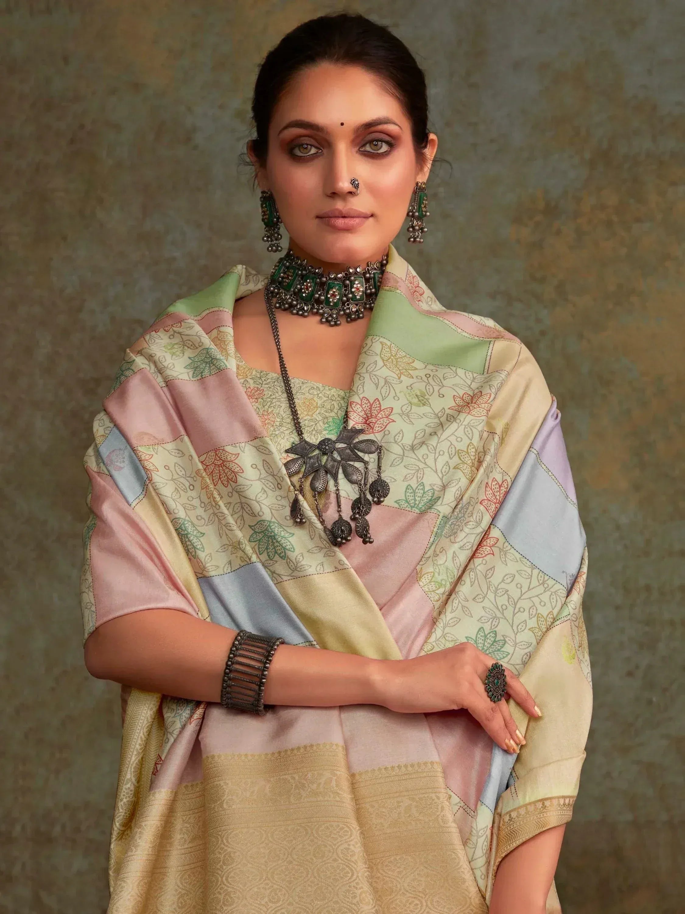 Woman in floral printed ethnic saree with pastel patchwork, traditional jewelry, and nose ring