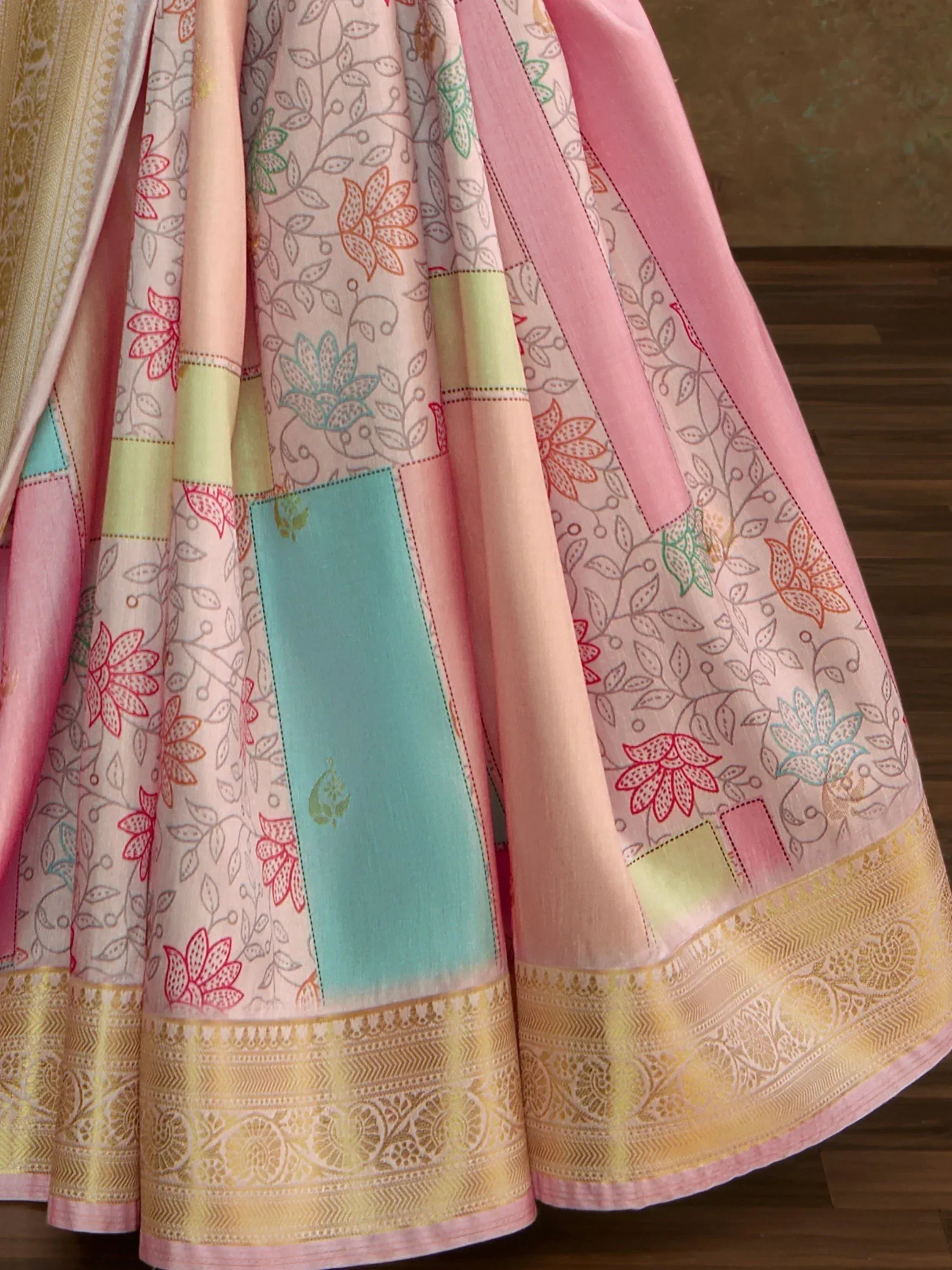Pink floral printed lehenga with gold border, patchwork design, and colorful panels for ethnic wear