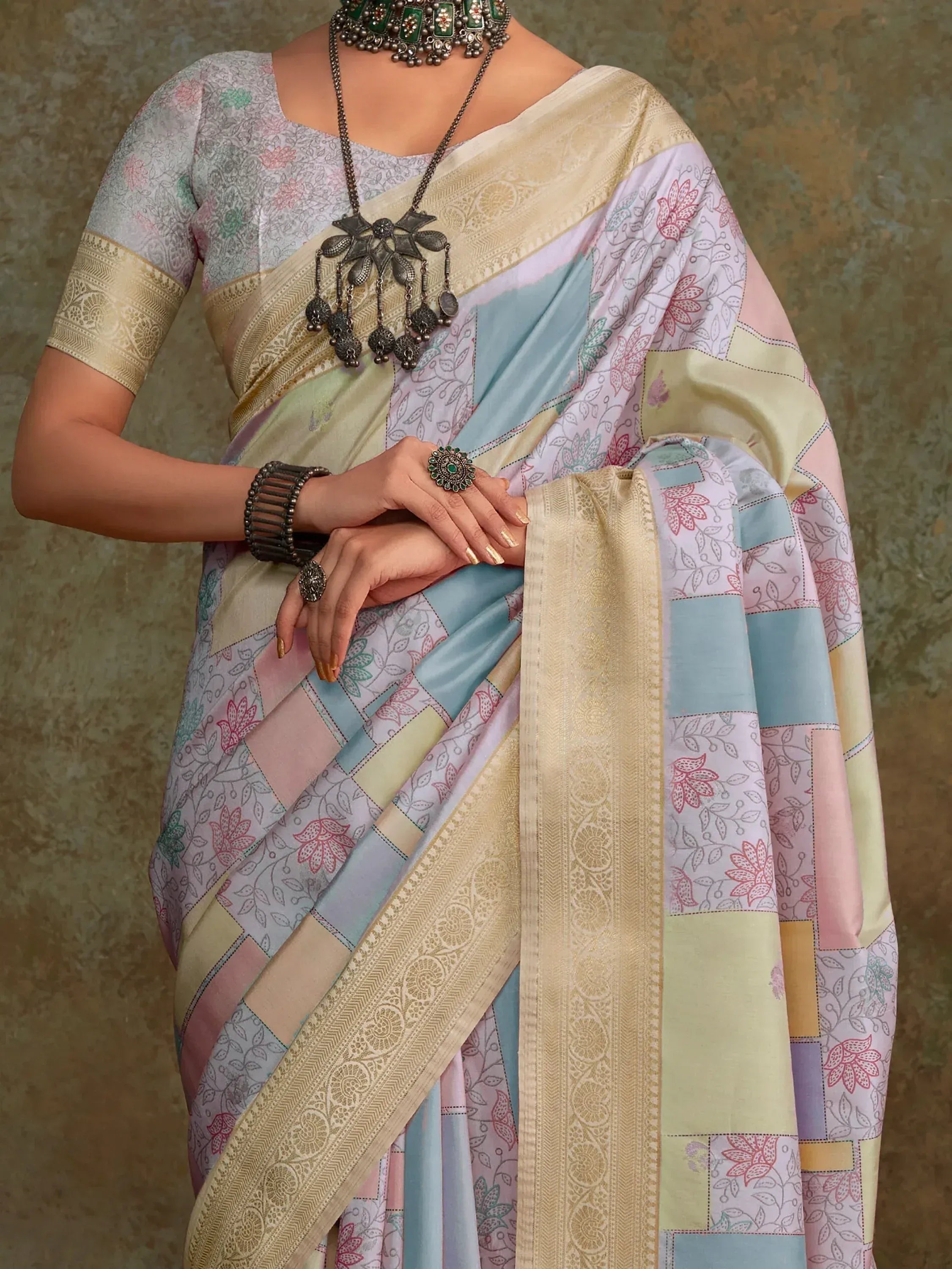 Pastel patchwork saree with floral print and gold border, styled with ethnic jewelry for traditional Indian wear