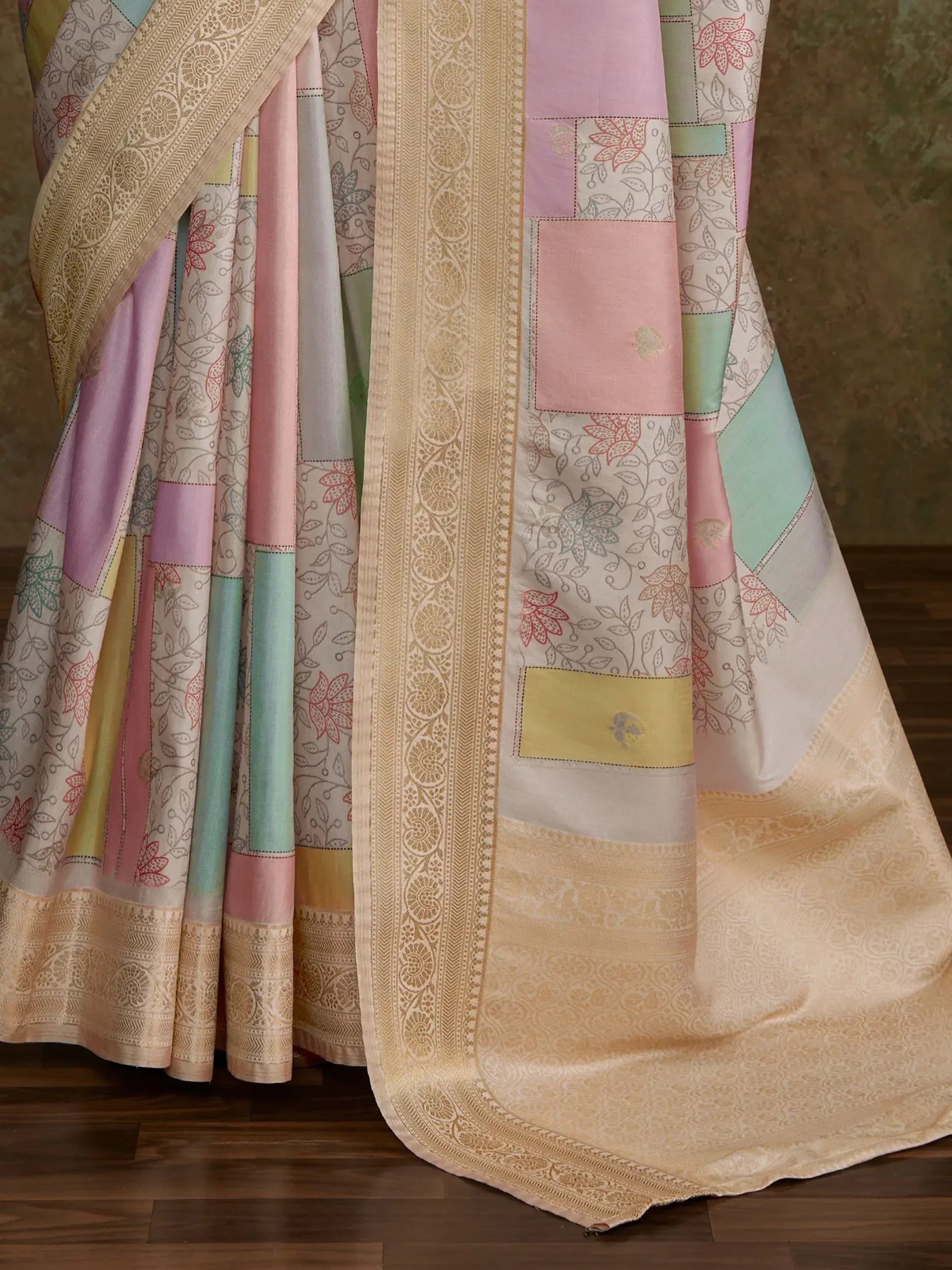 Pastel patchwork saree with floral prints and golden border, ideal for ethnic wear occasions