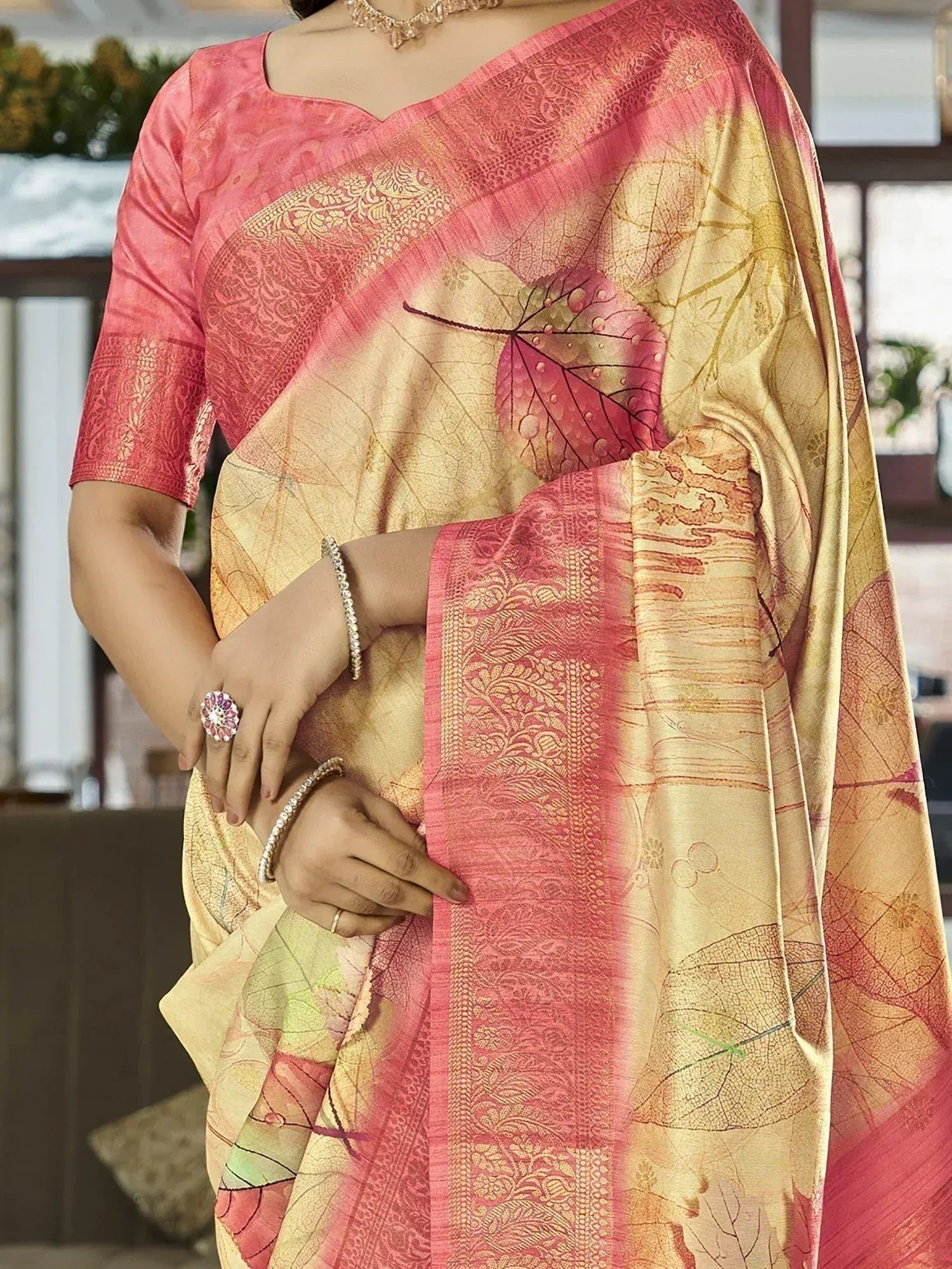 Elegant pink and gold saree with leaf print and intricate border design