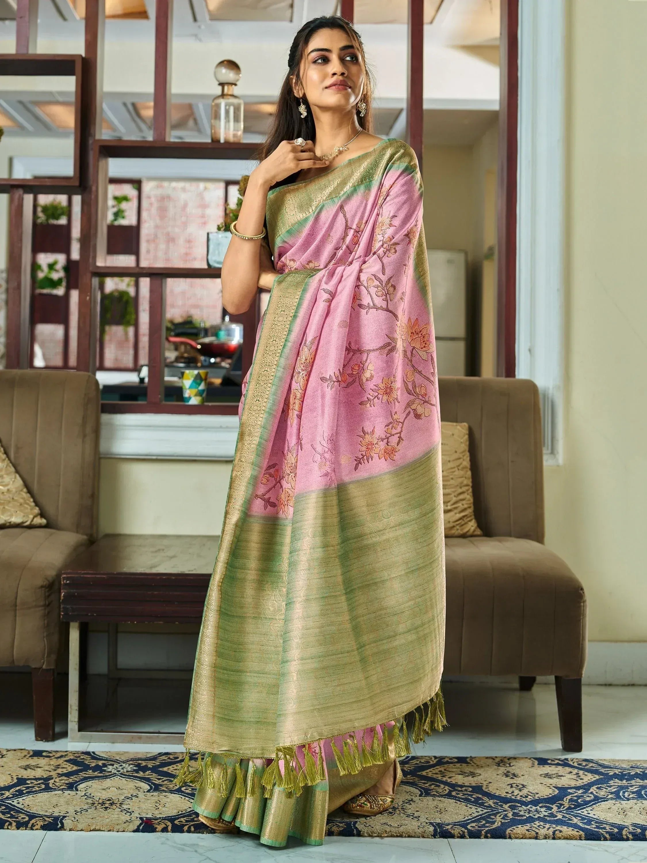 Pink and green floral saree with golden border and tassels, styled for ethnic wear