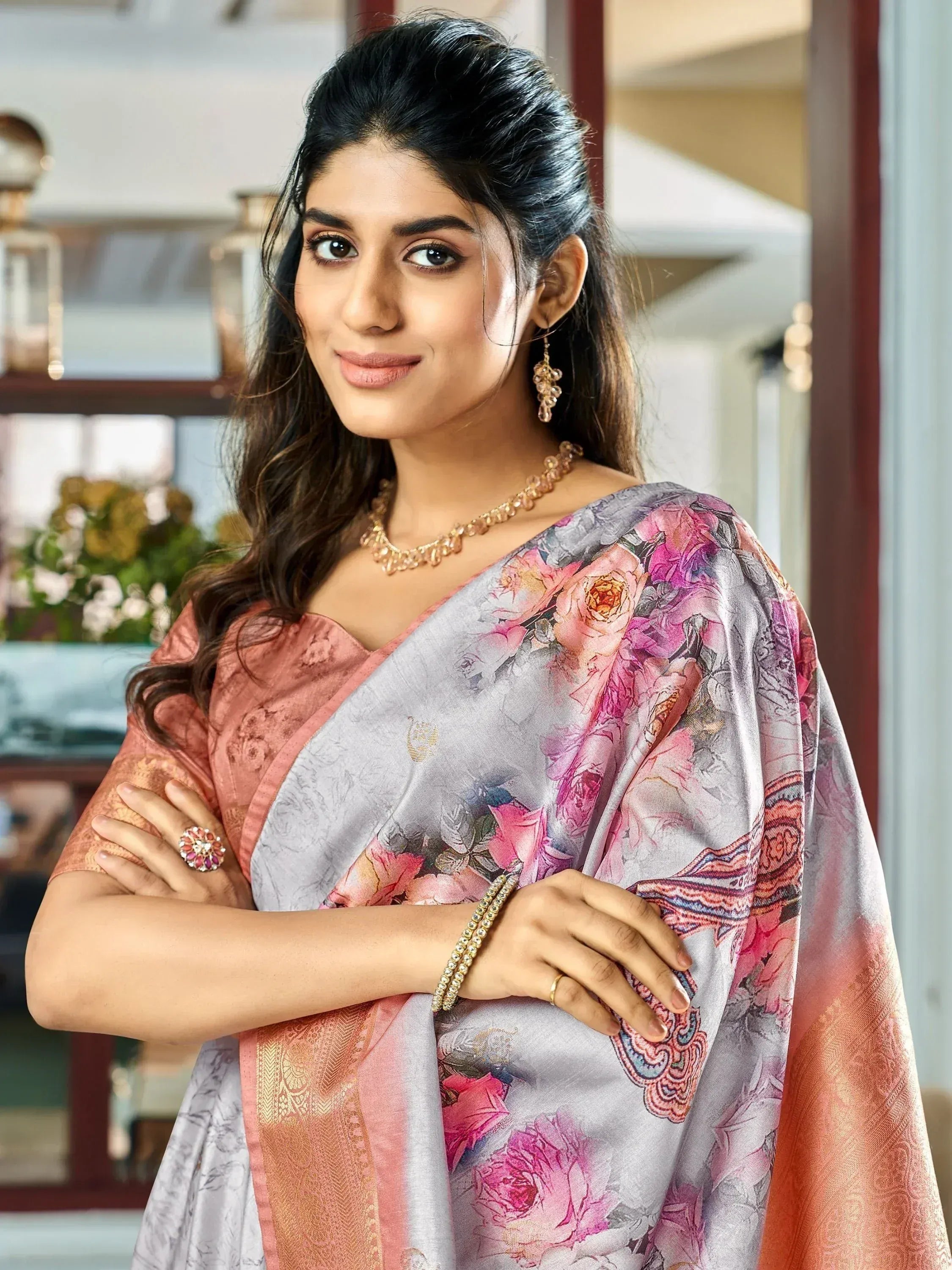 Elegant woman in floral saree with gold jewelry, showcasing Indian ethnic wear