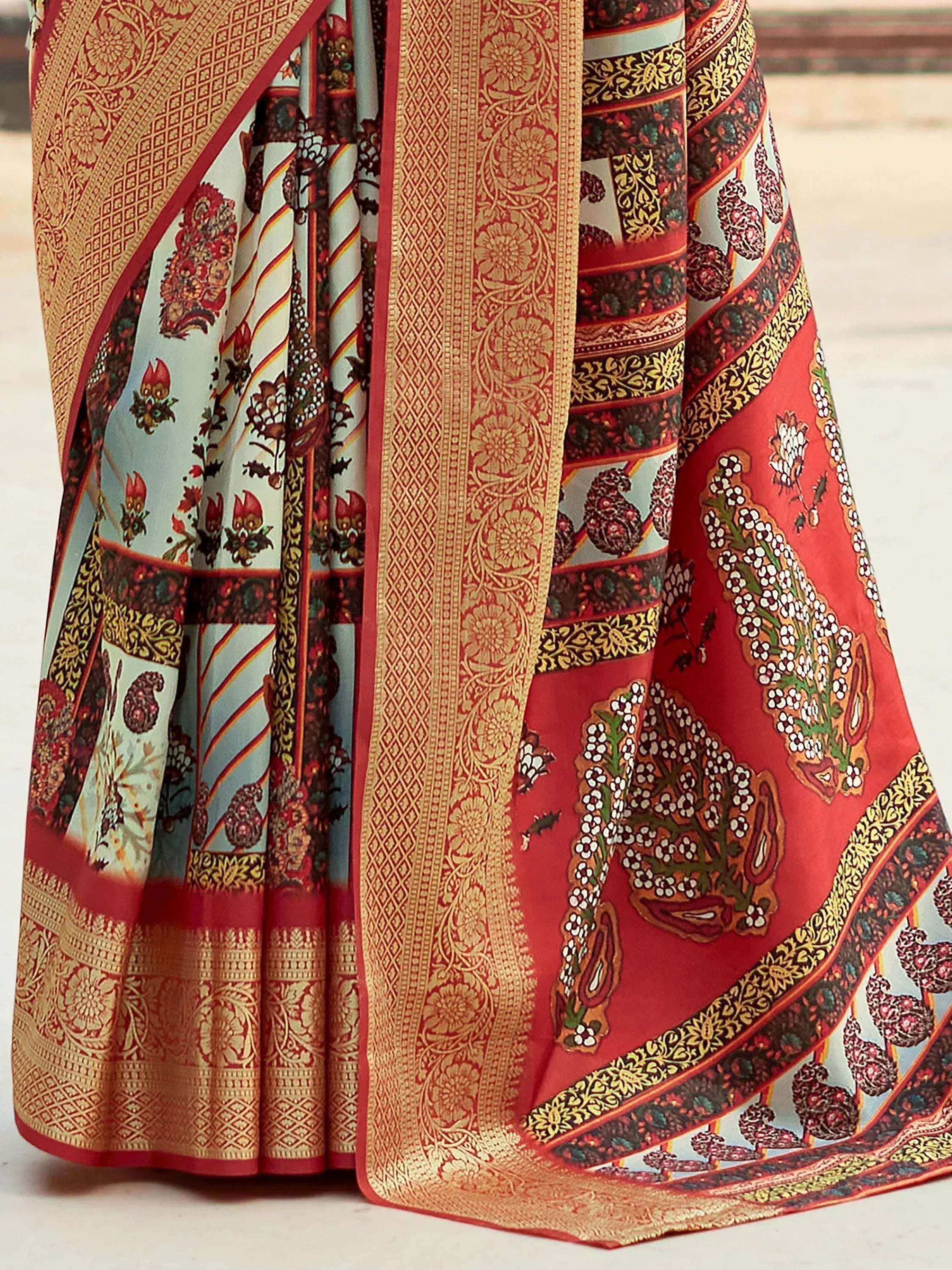 Red and gold printed saree with intricate paisley and floral motifs, perfect for ethnic occasions.