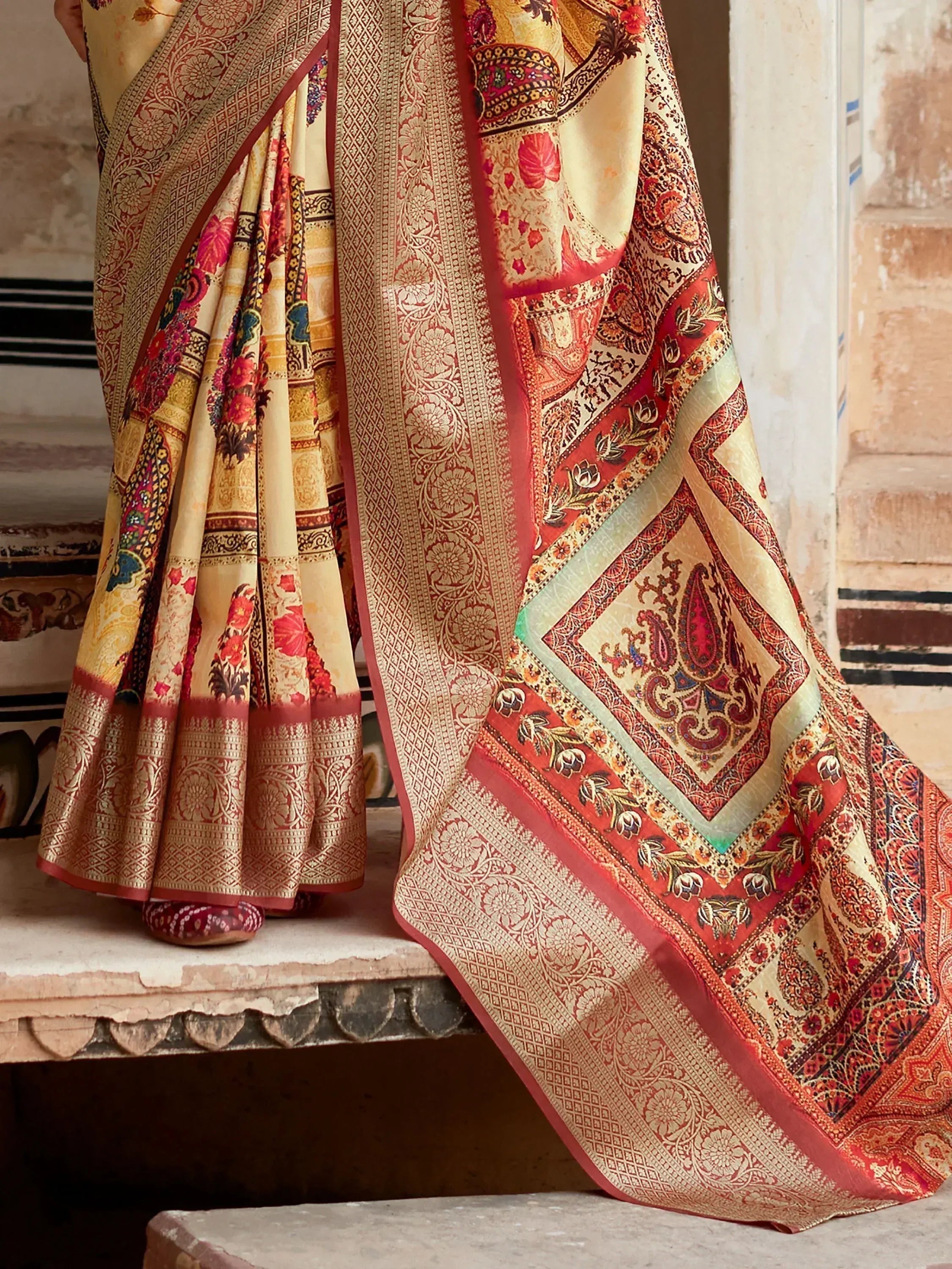 Elegant Indian saree with intricate paisley and floral motifs in red, gold, and cream, perfect for ethnic occasions.
