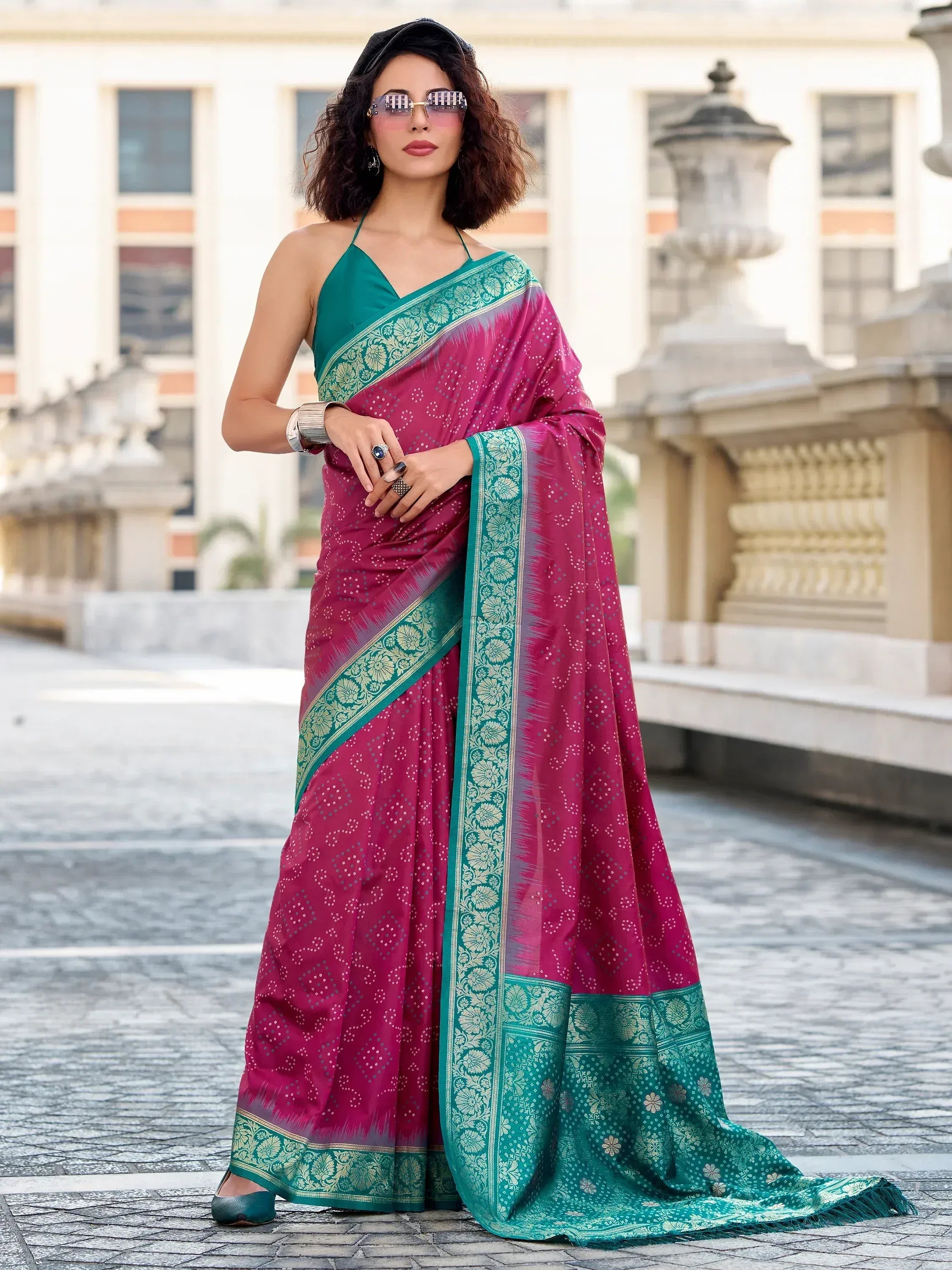 Woman in elegant magenta and teal saree with floral border, styled for Indian ethnic wear