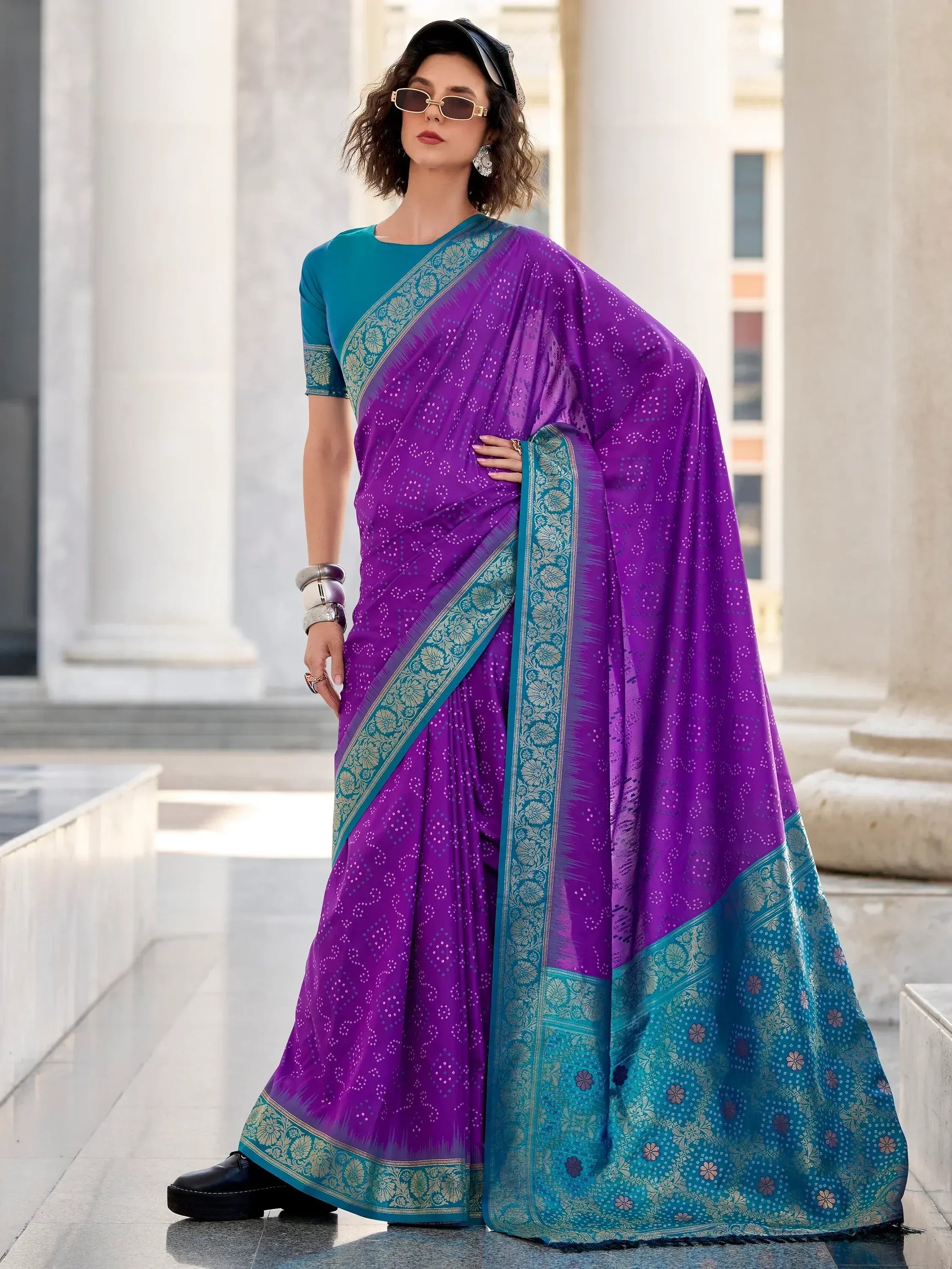 Purple and teal designer saree with floral border, styled with modern accessories for ethnic wear
