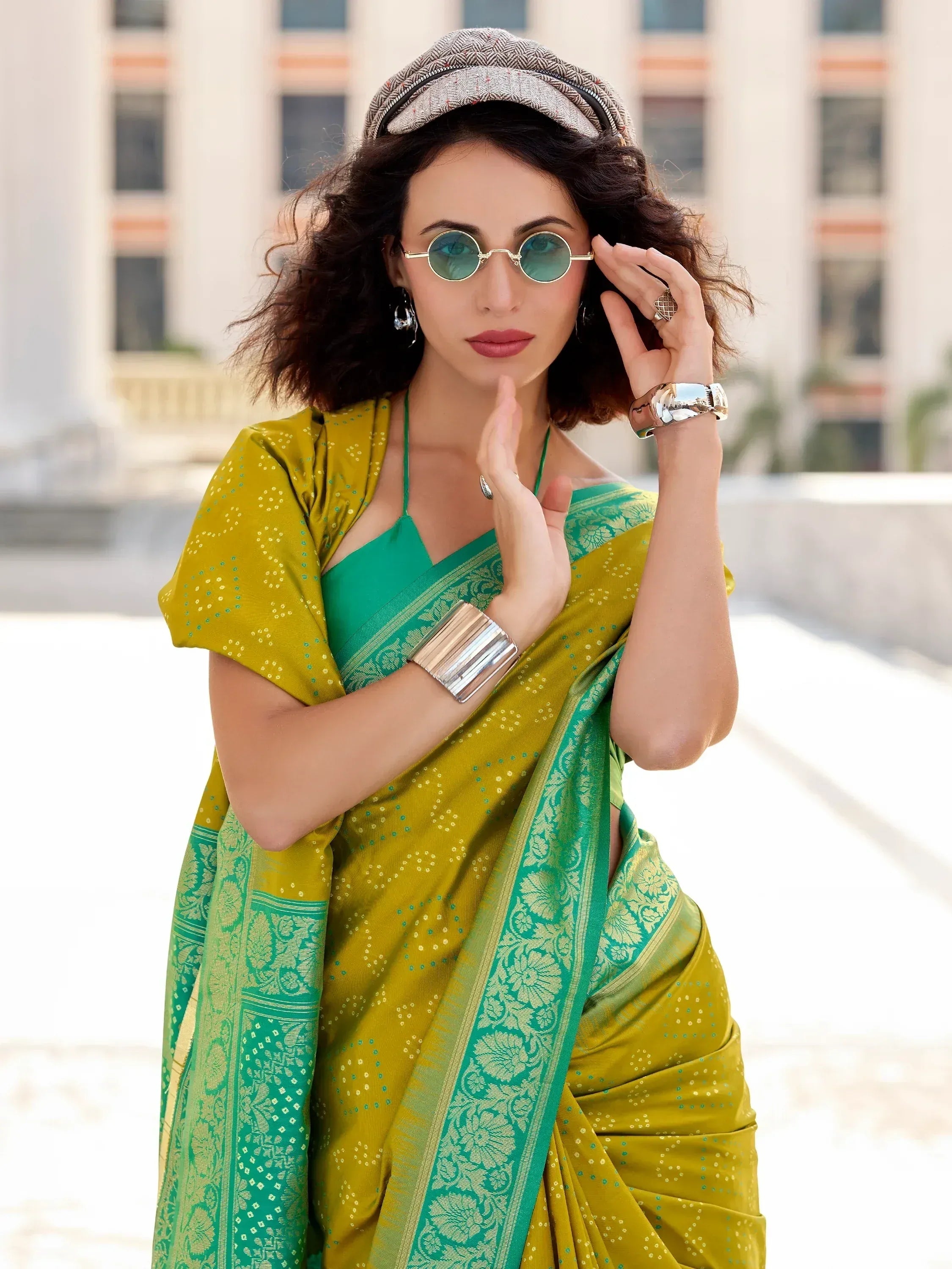 Stylish woman in green and yellow ethnic saree with cap and sunglasses, modern Indian fashion
