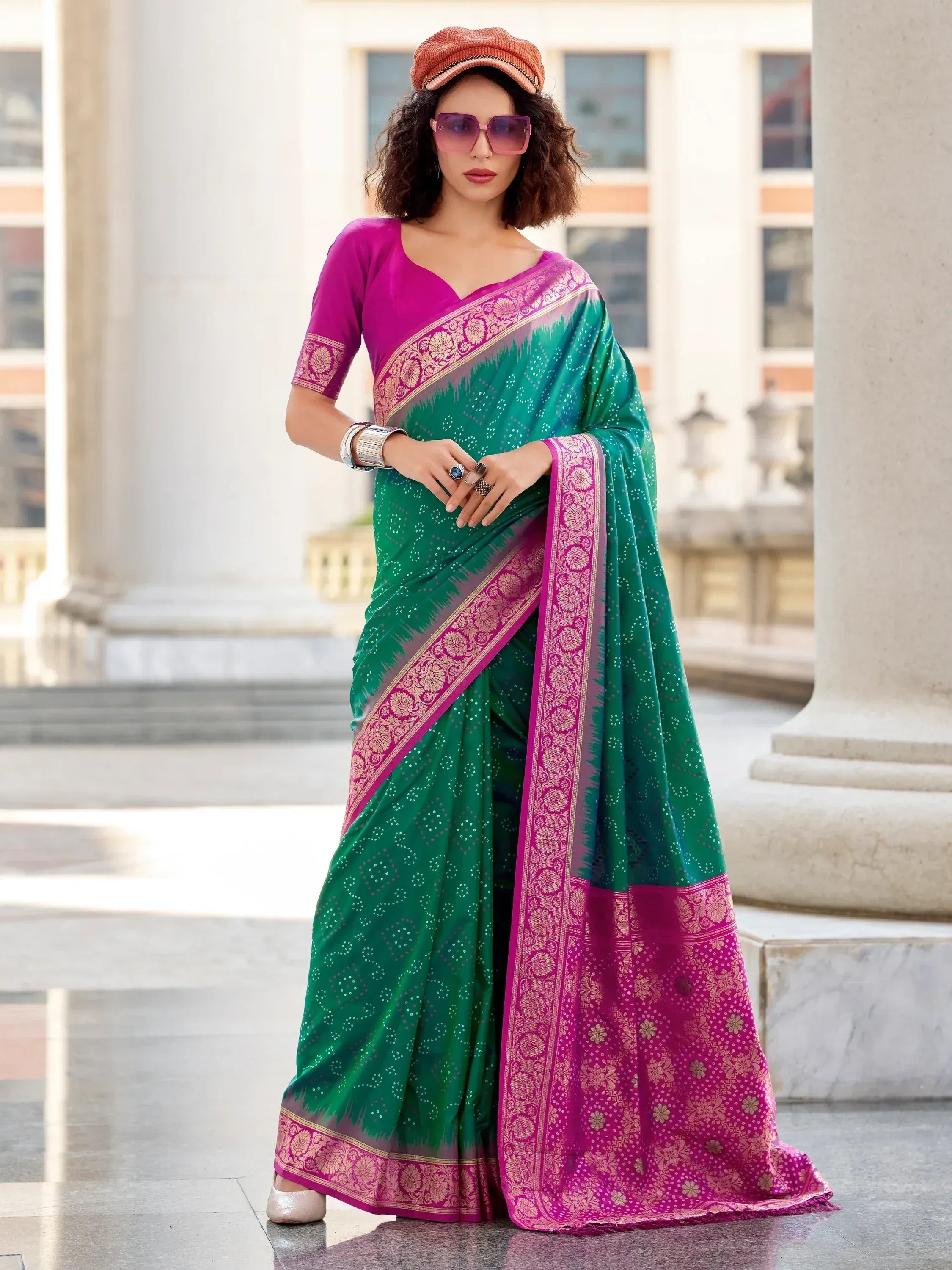Green and pink ethnic saree with gold floral border, styled with cap and sunglasses for modern Indian wear