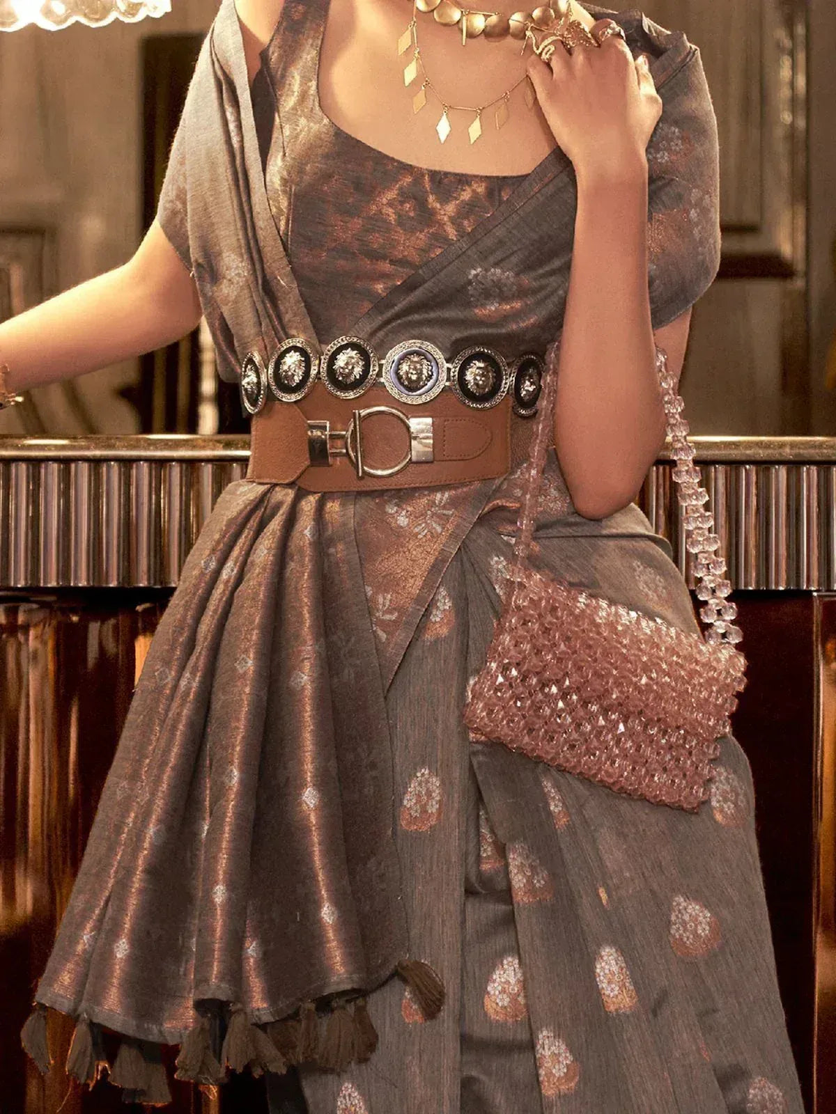 Stylish ethnic gown with metallic print, lion-head belt, and crystal bag for festive occasions