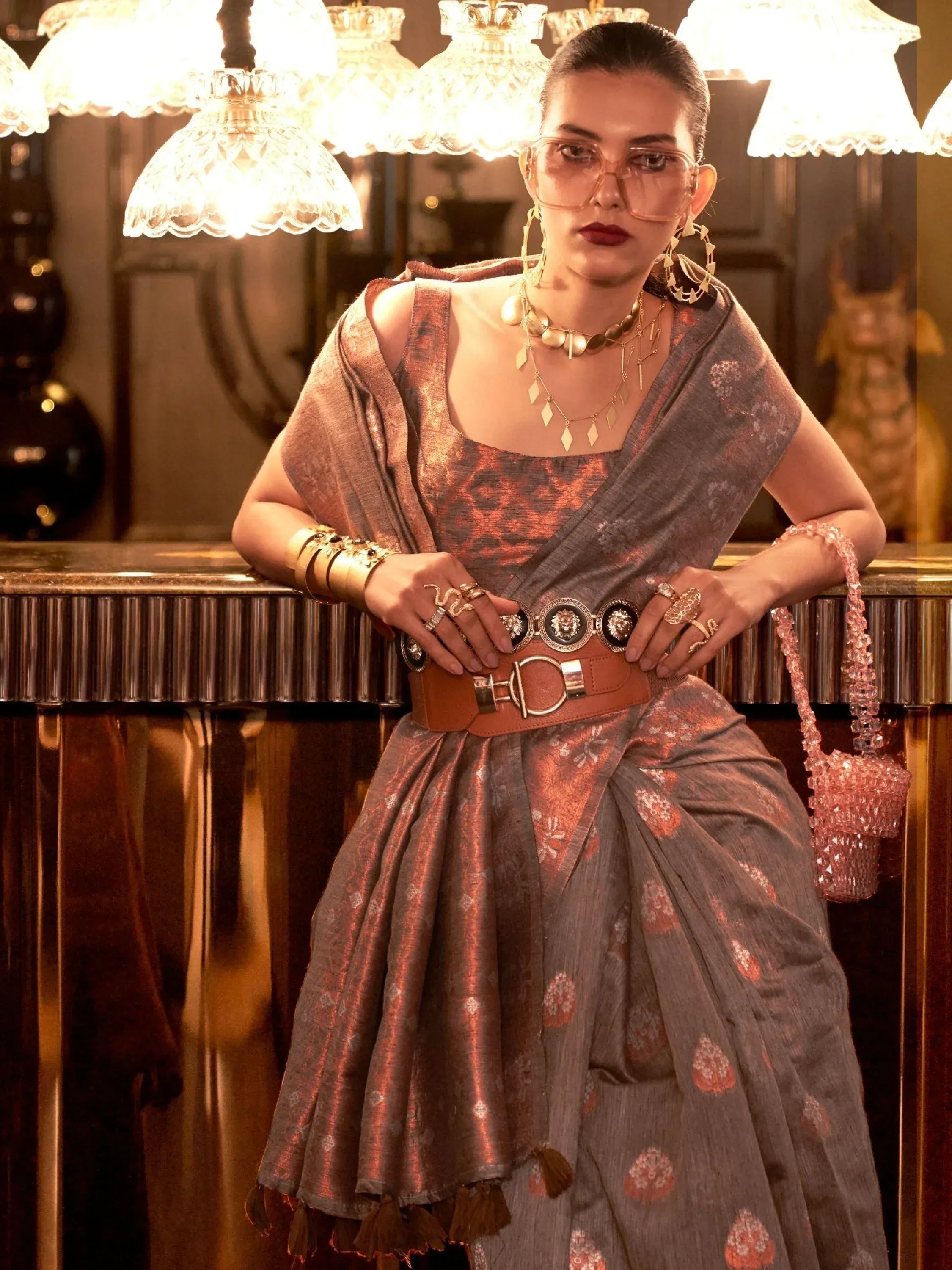 Stylish woman in ethnic saree with gold jewelry and statement belt, perfect for festive occasions