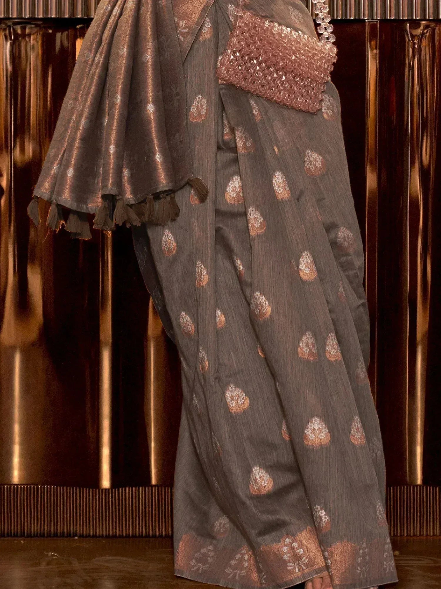 Grey saree with copper floral motifs and tassels, paired with embellished blouse, ideal for ethnic occasions.