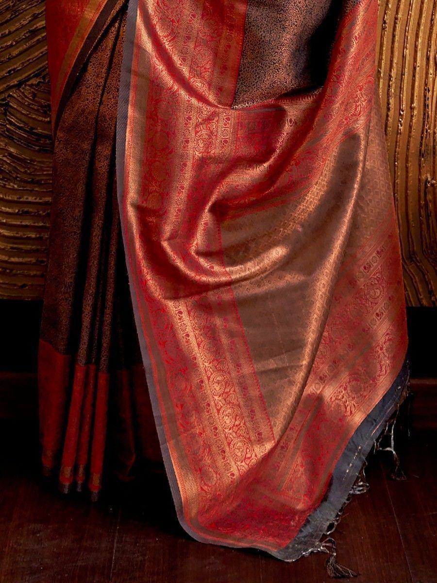 Red and gold designer saree with intricate brocade patterns and tassels, perfect for ethnic occasions