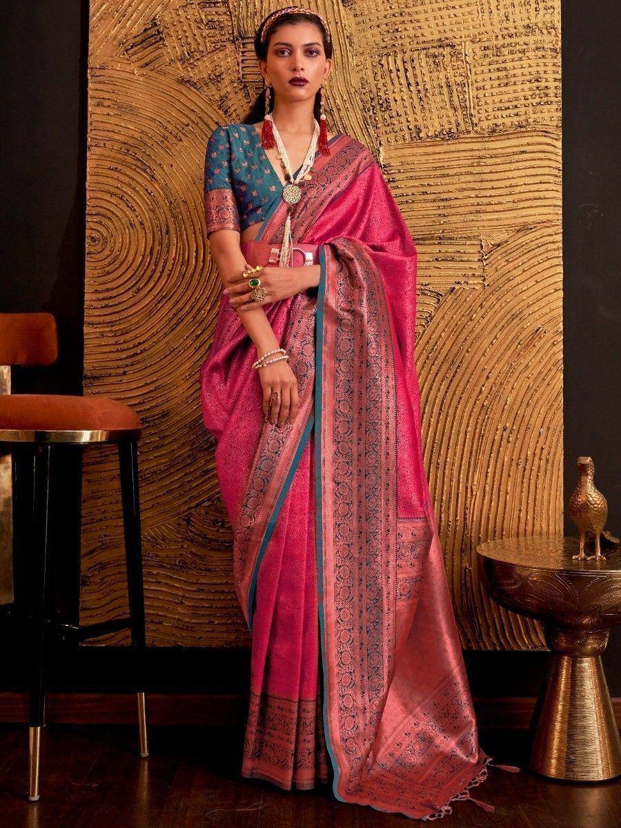 Pink and teal designer saree with intricate embroidery, paired with matching blouse and traditional jewelry