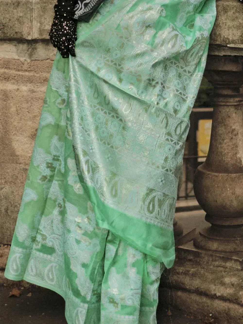 Mint green paisley saree with silver zari work, paired with black sequin blouse, perfect for ethnic occasions.