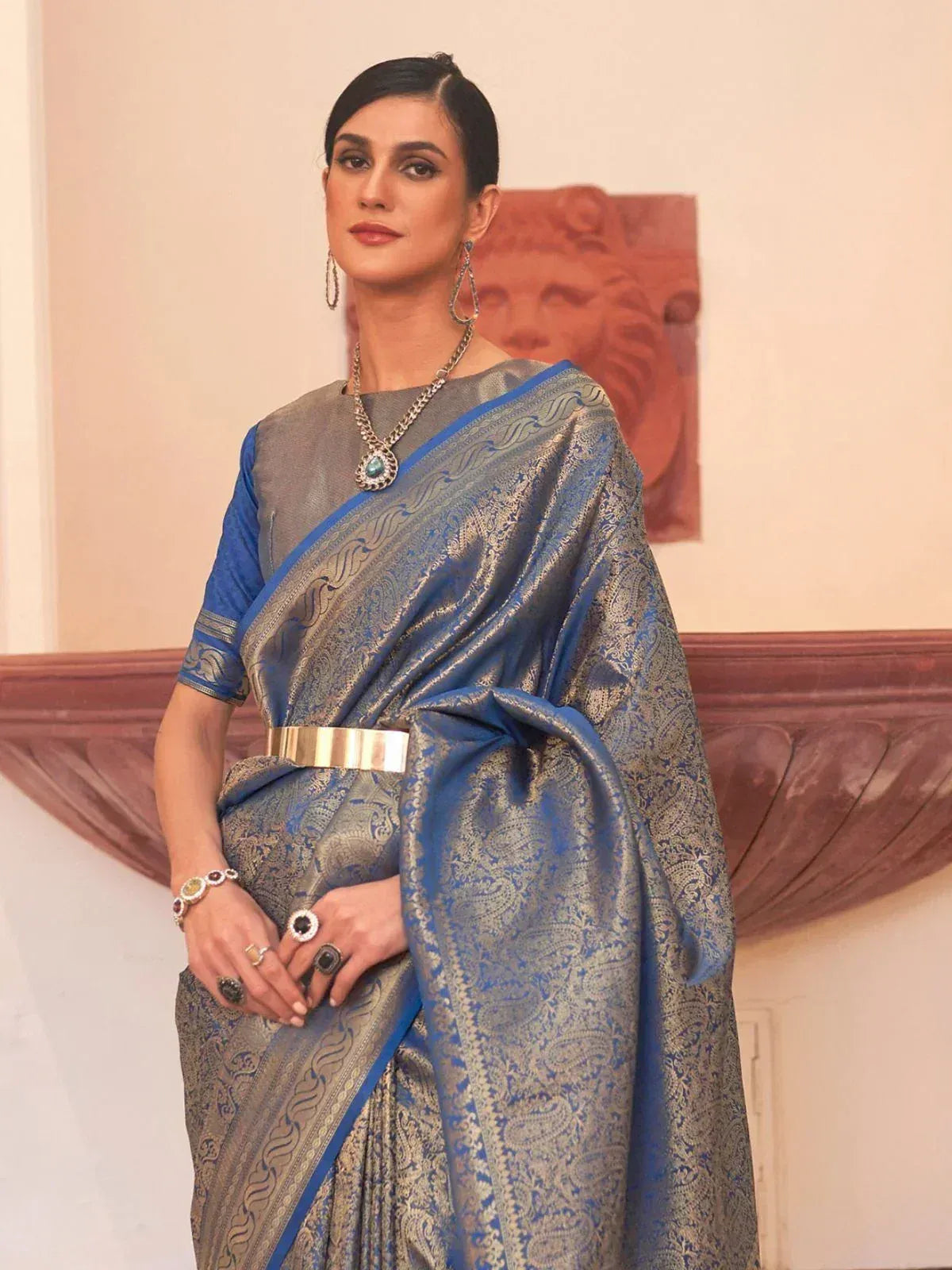 Blue and silver designer saree with intricate paisley patterns, paired with statement jewelry for ethnic wear
