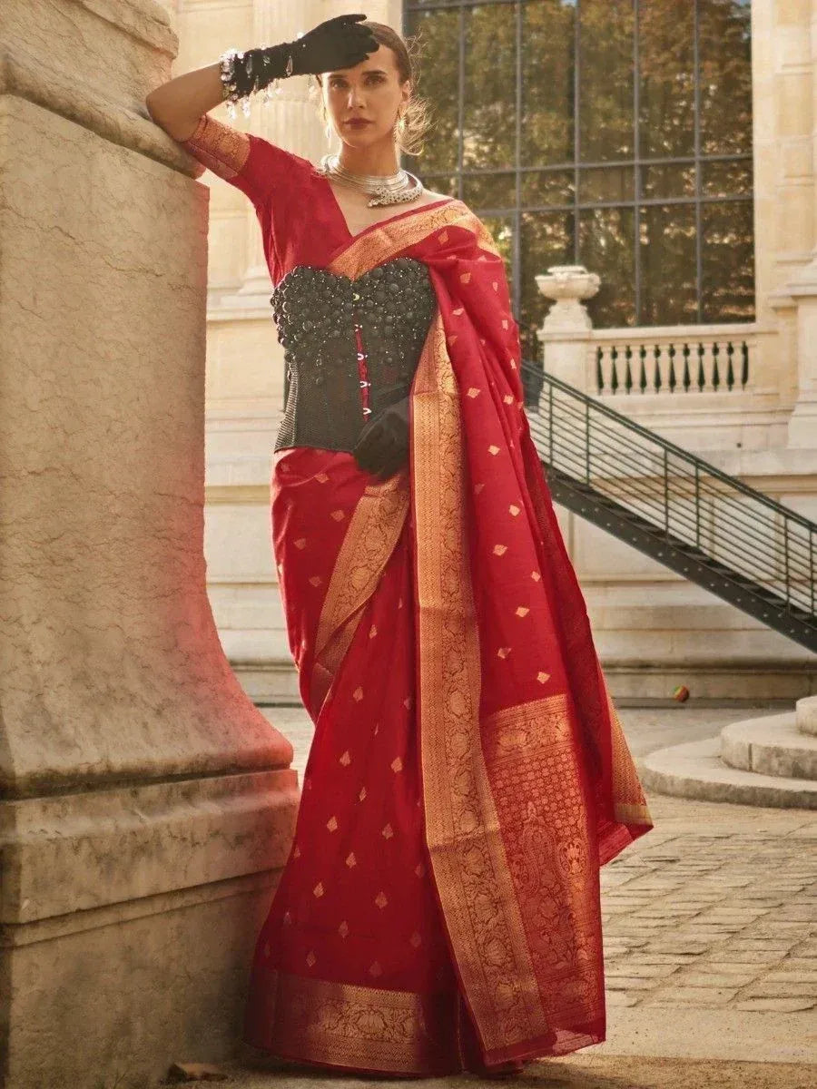 Red designer saree with gold border and black embellished blouse, styled with gloves and jewelry