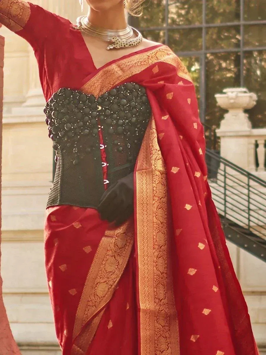 Red ethnic saree with black embellished corset blouse, gold border, and traditional jewelry