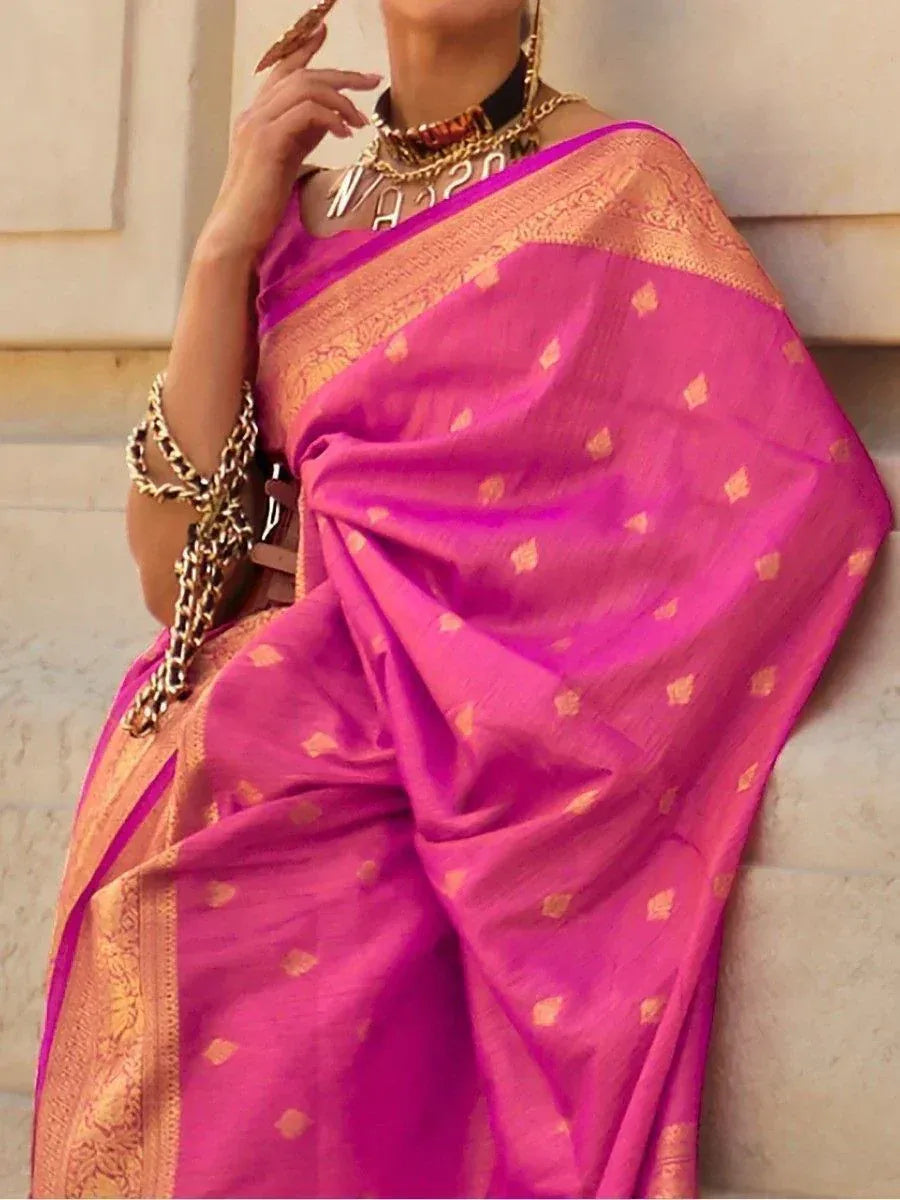 Vibrant pink saree with gold motifs and border, styled with statement jewelry for ethnic occasions